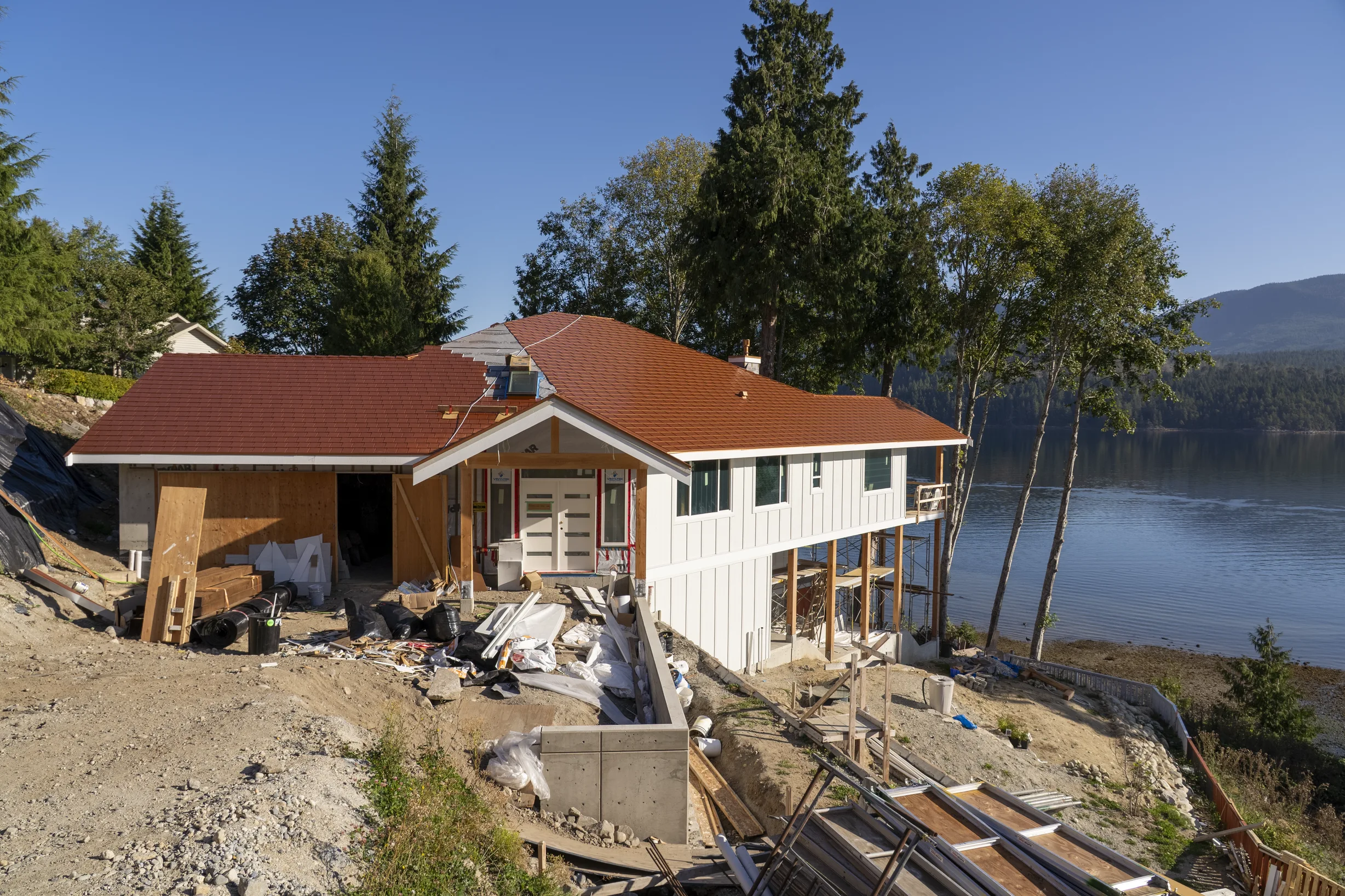 Copper Penny Interlock Slate aluminum roof being installed on the home, replacing new construction, Sechelt, British Columbia