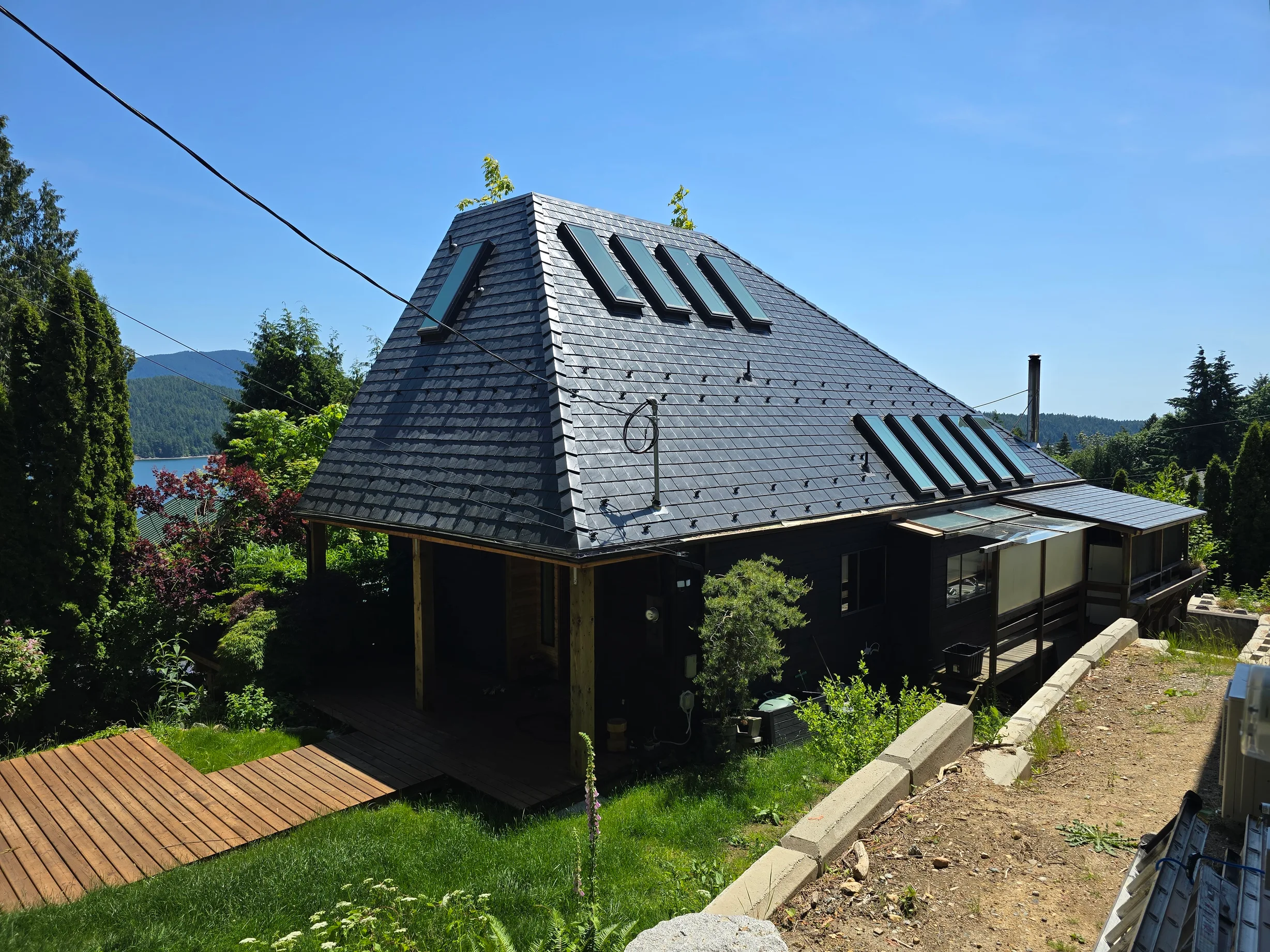 Deep Charcoal Interlock Slate aluminum roof on a Deep Charcoal metal roof on a home overlooking the ocean, Gibsons, British Columbia