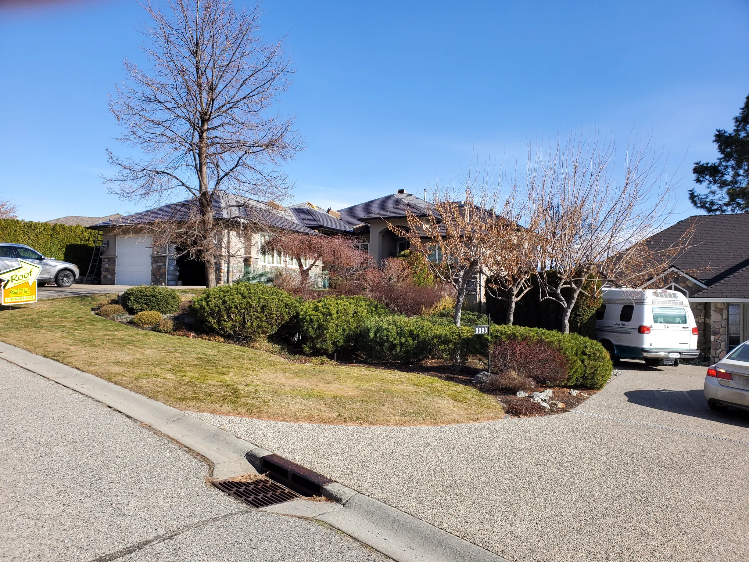 Tudor Brown Interlock Cedar Shingle aluminum roof on a Tudor brown single-family home in a suburban setting, West Kelowna, British Columbia