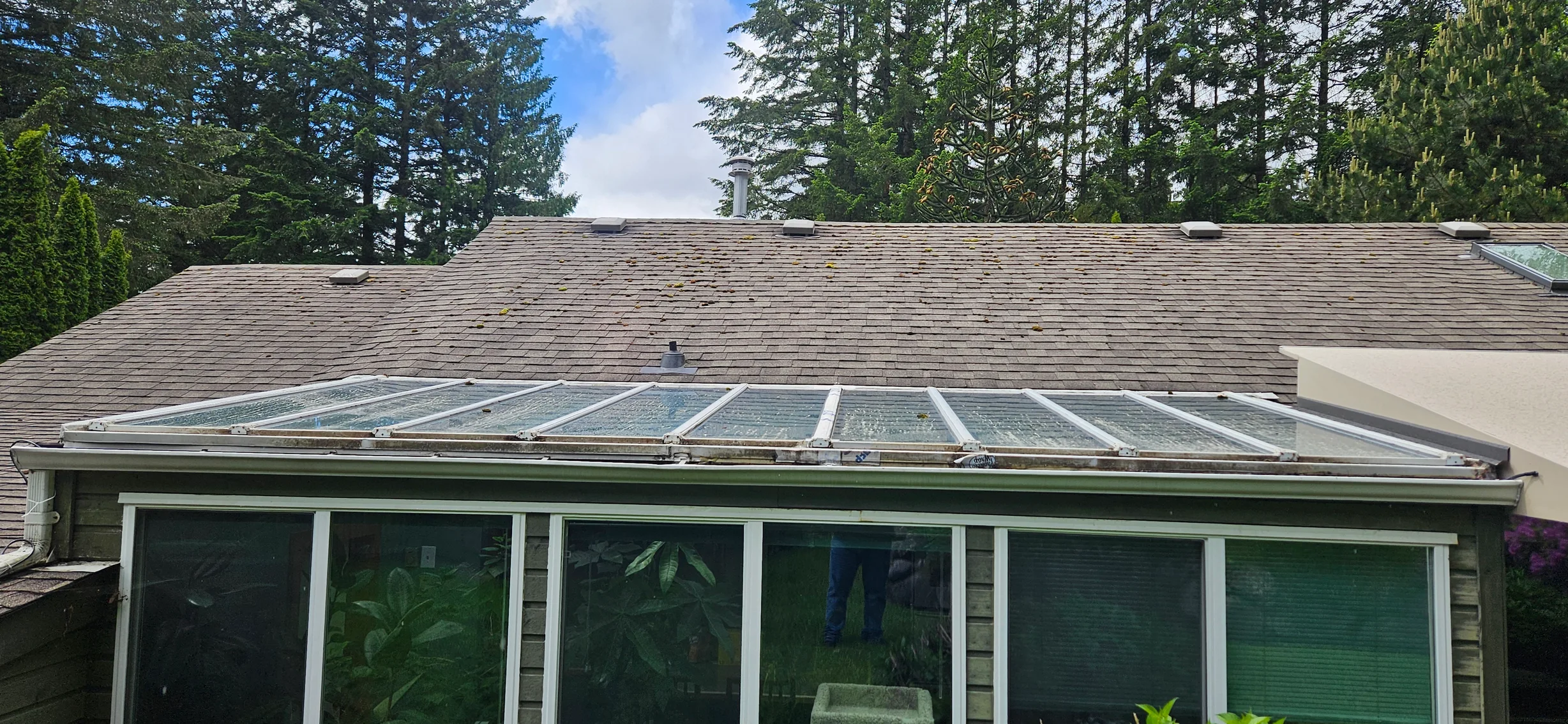 Before: a mossy asphalt shingle roof on the home, Squamish, British Columbia, ahead of a Tudor Brown Interlock Slate aluminum roof