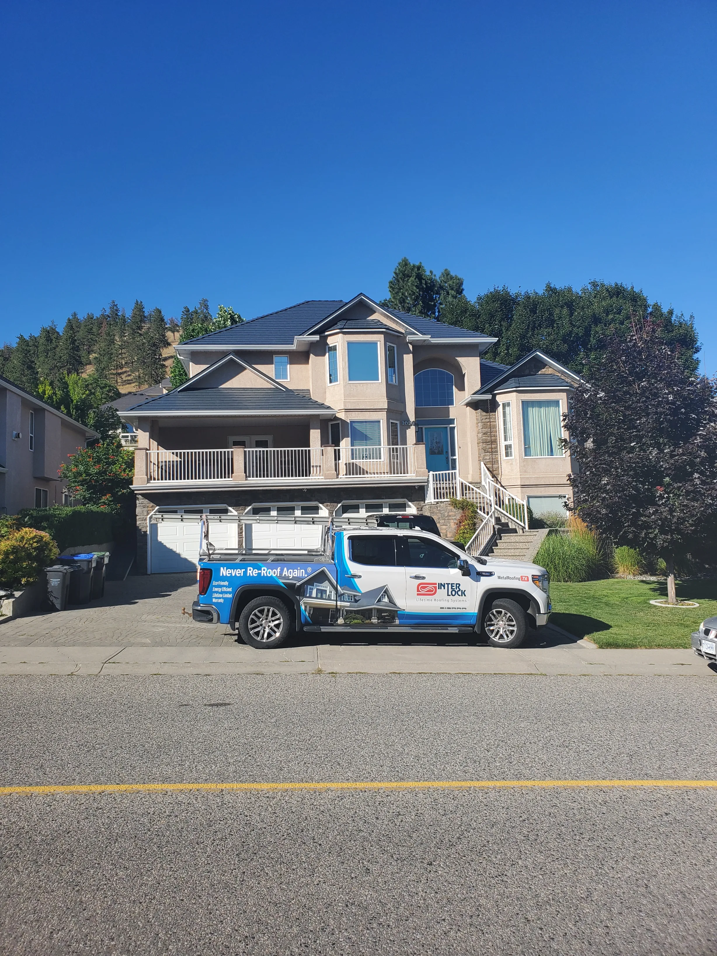 Deep Charcoal Interlock Slate aluminum roof on a modern single-family home with a metal roof in a forested, Kelowna, British Columbia