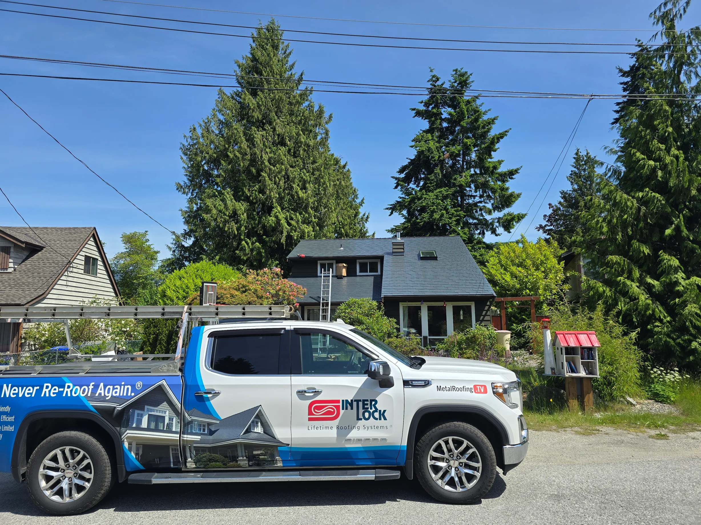 Deep Charcoal Interlock Slate aluminum roof on a gray two-storey home with dormers in a coastal urban, Sechelt, British Columbia