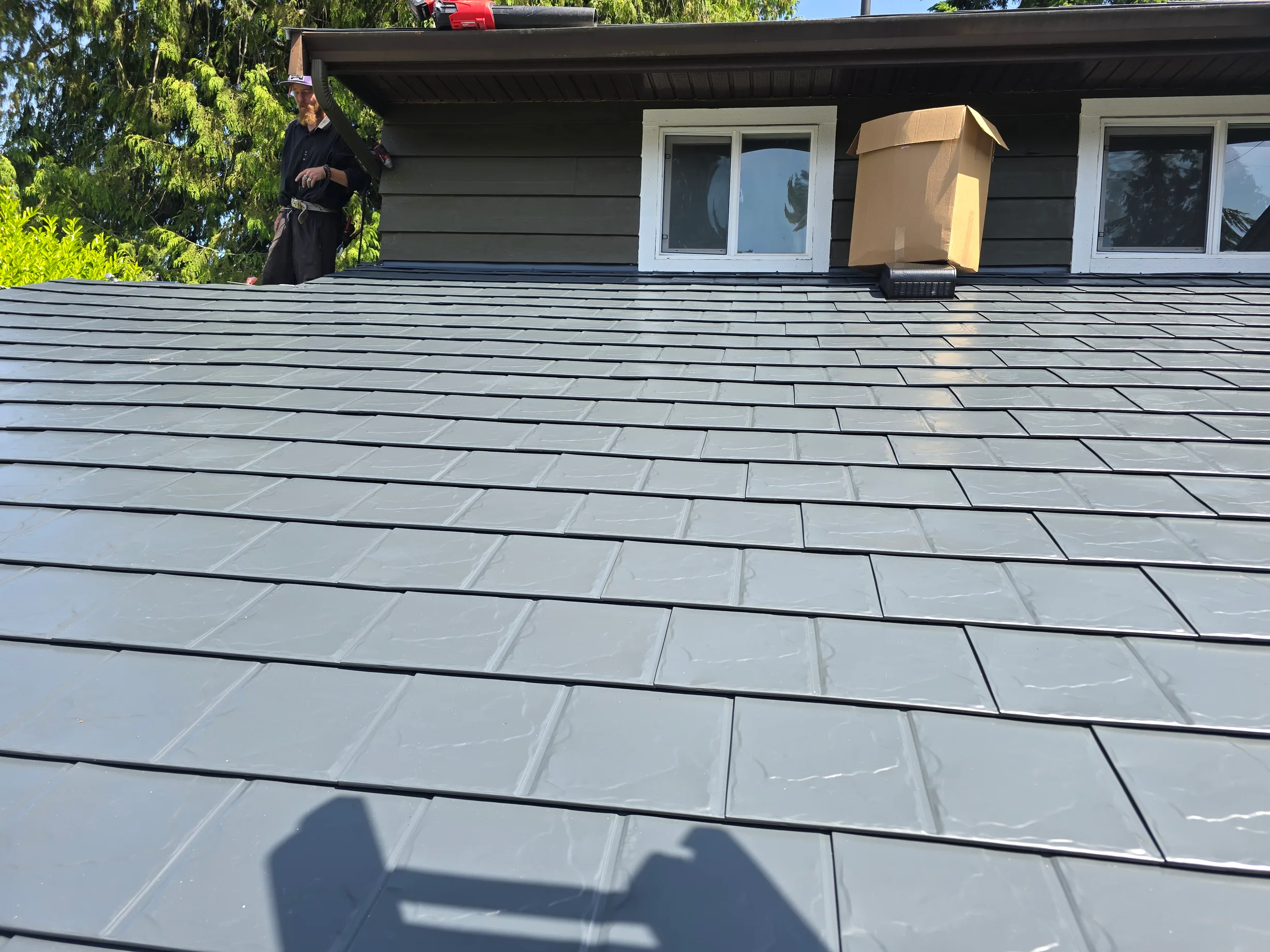 Deep Charcoal Interlock Slate aluminum roof on a deep charcoal single-family home with a metal roof among, Sechelt, British Columbia