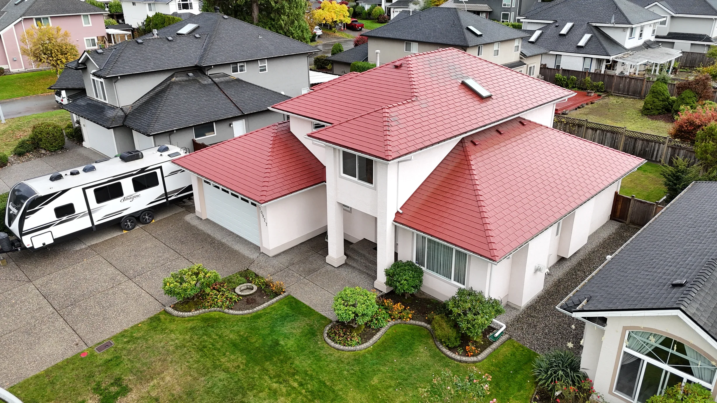 Tile Red Interlock Shingle aluminum roof on a two-storey home with red metal roof in a suburban, Surrey, British Columbia