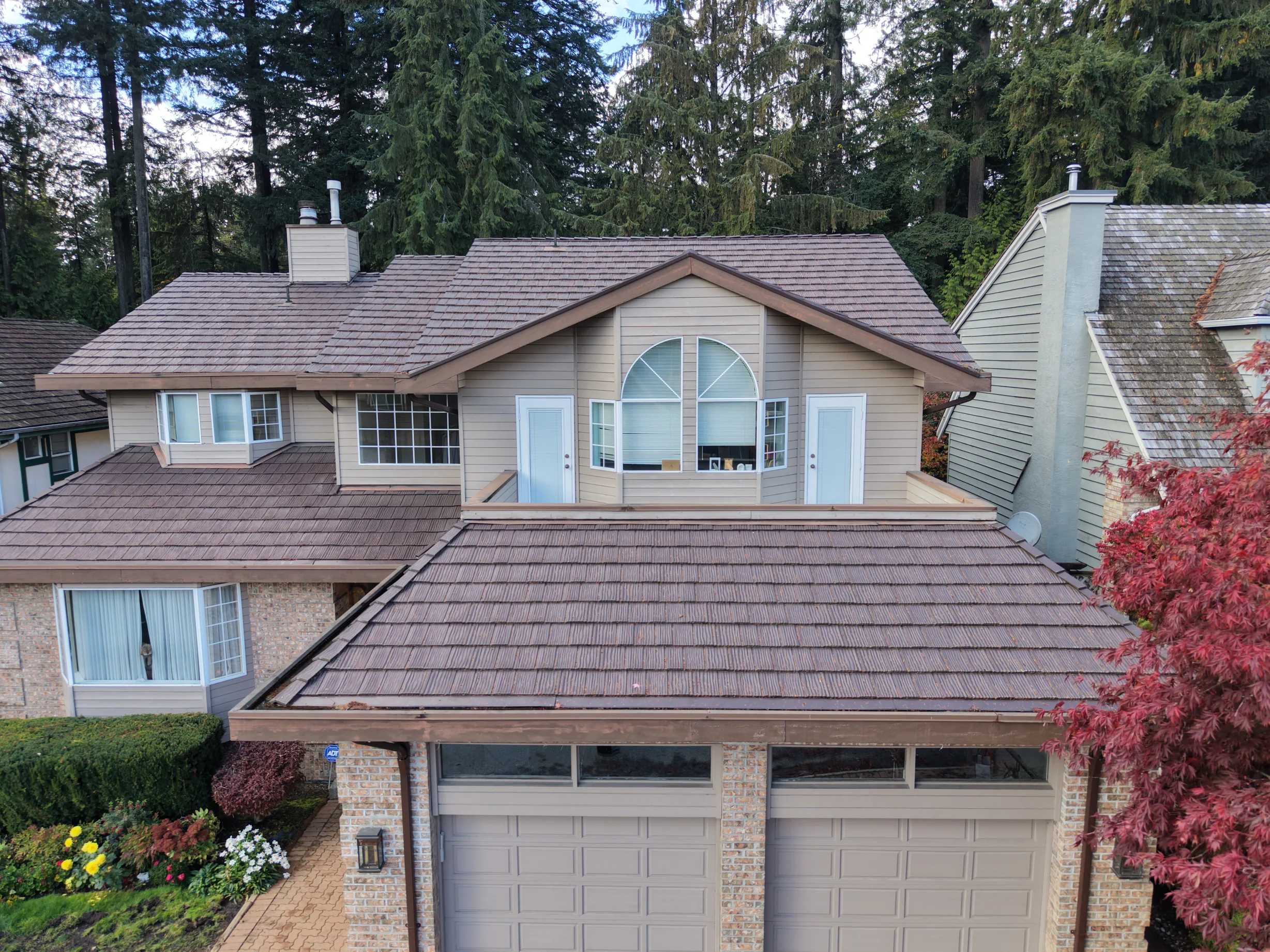 Colonial Brown Interlock Shake aluminum roof on a colonial home with a metal roof in a forested area, North Vancouver, British Columbia