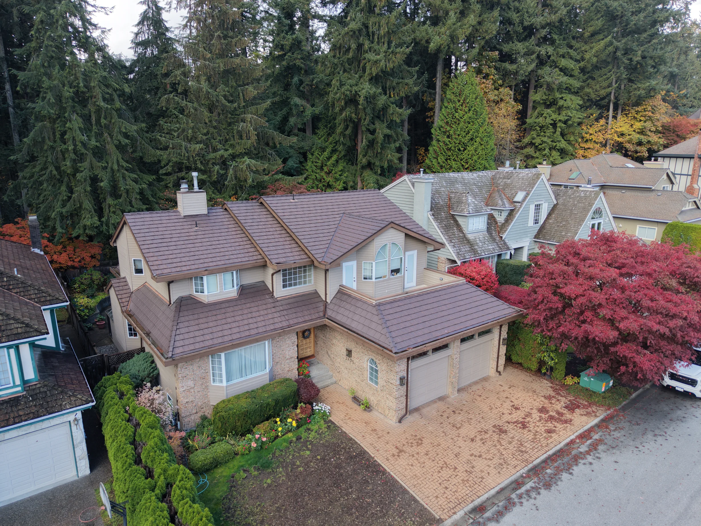 Colonial Brown Interlock Shake aluminum roof on a colonial style home with a brown roof among evergreens, North Vancouver, British Columbia