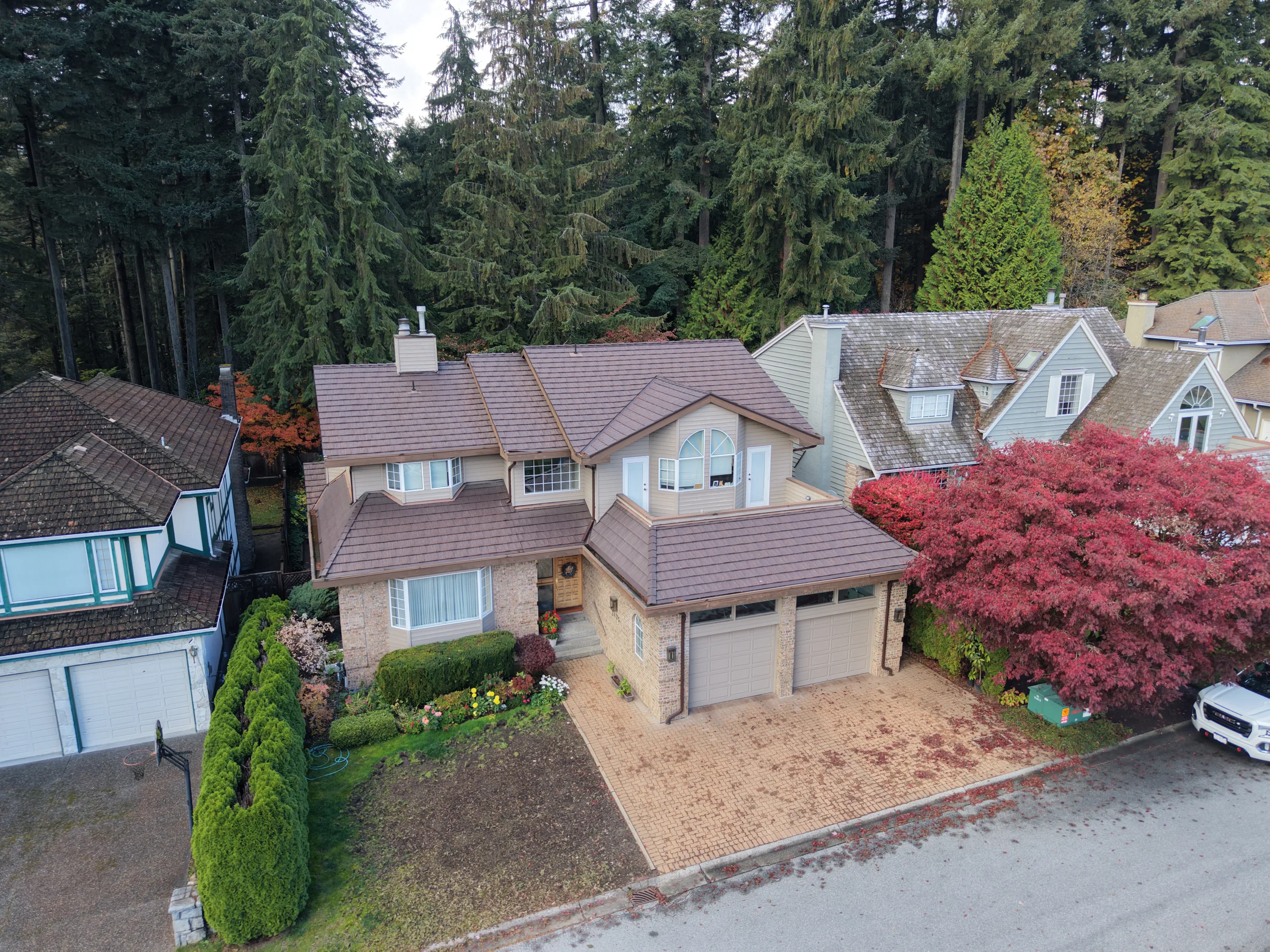 Colonial Brown Interlock Shake aluminum roof on a Colonial home with brown roof among tall trees, North Vancouver, British Columbia