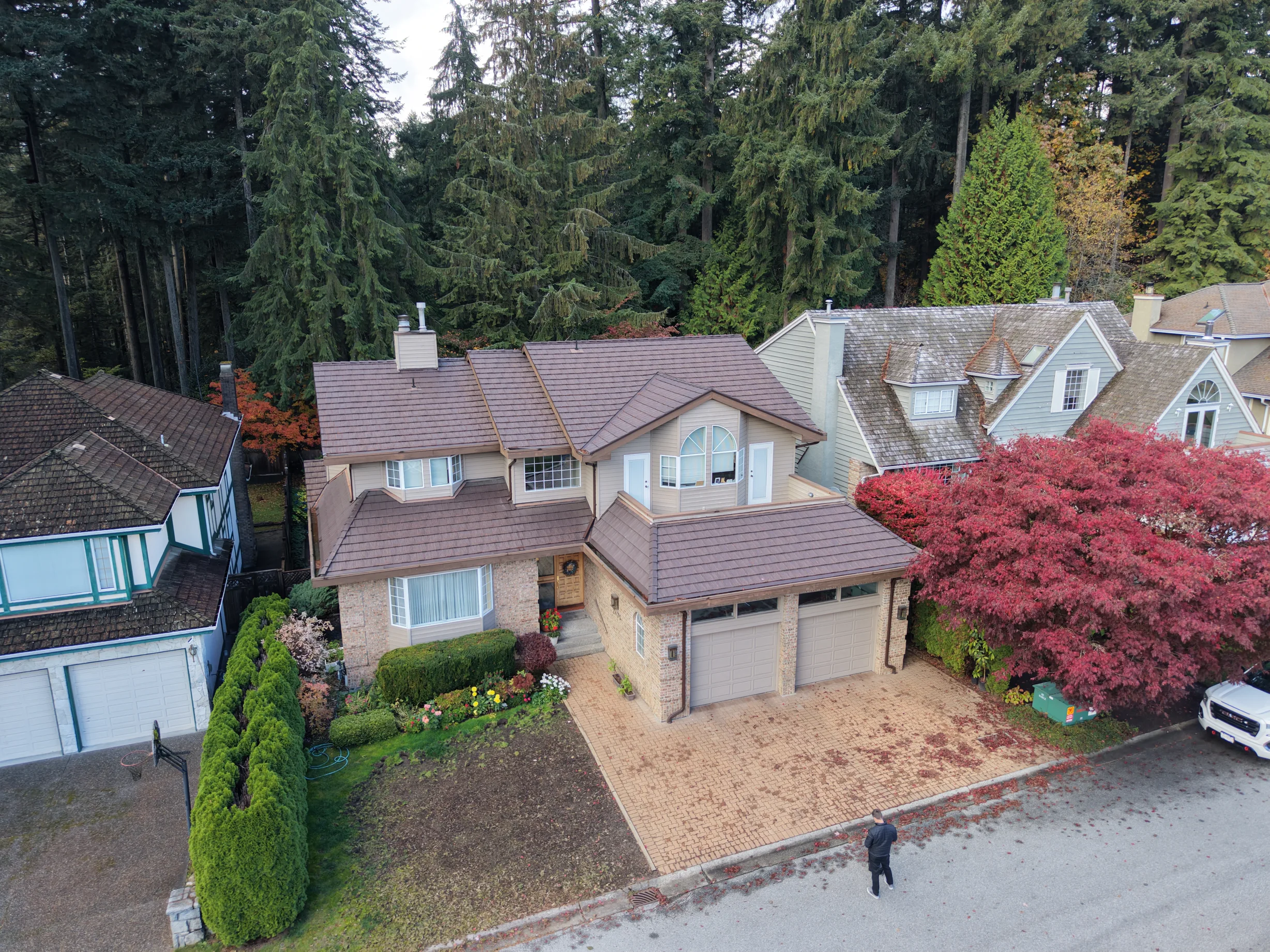 Colonial Brown Interlock Shake aluminum roof on a Colonial-style two-storey home with dormers in a forested, North Vancouver, British Columbia