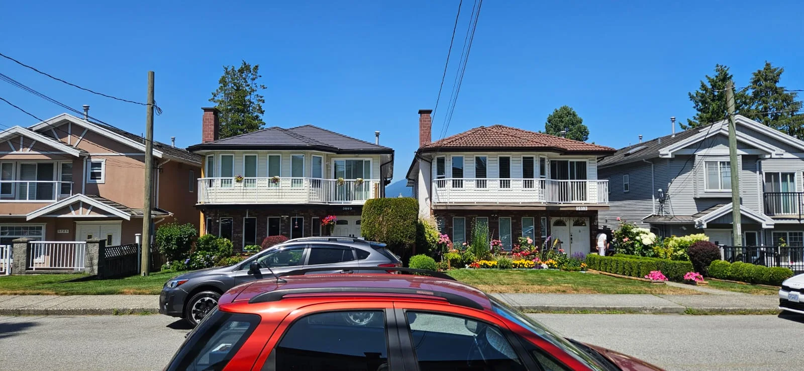Black Interlock Slate aluminum roof being installed on a two-storey suburban home with a metal roof under, Burnaby, British Columbia
