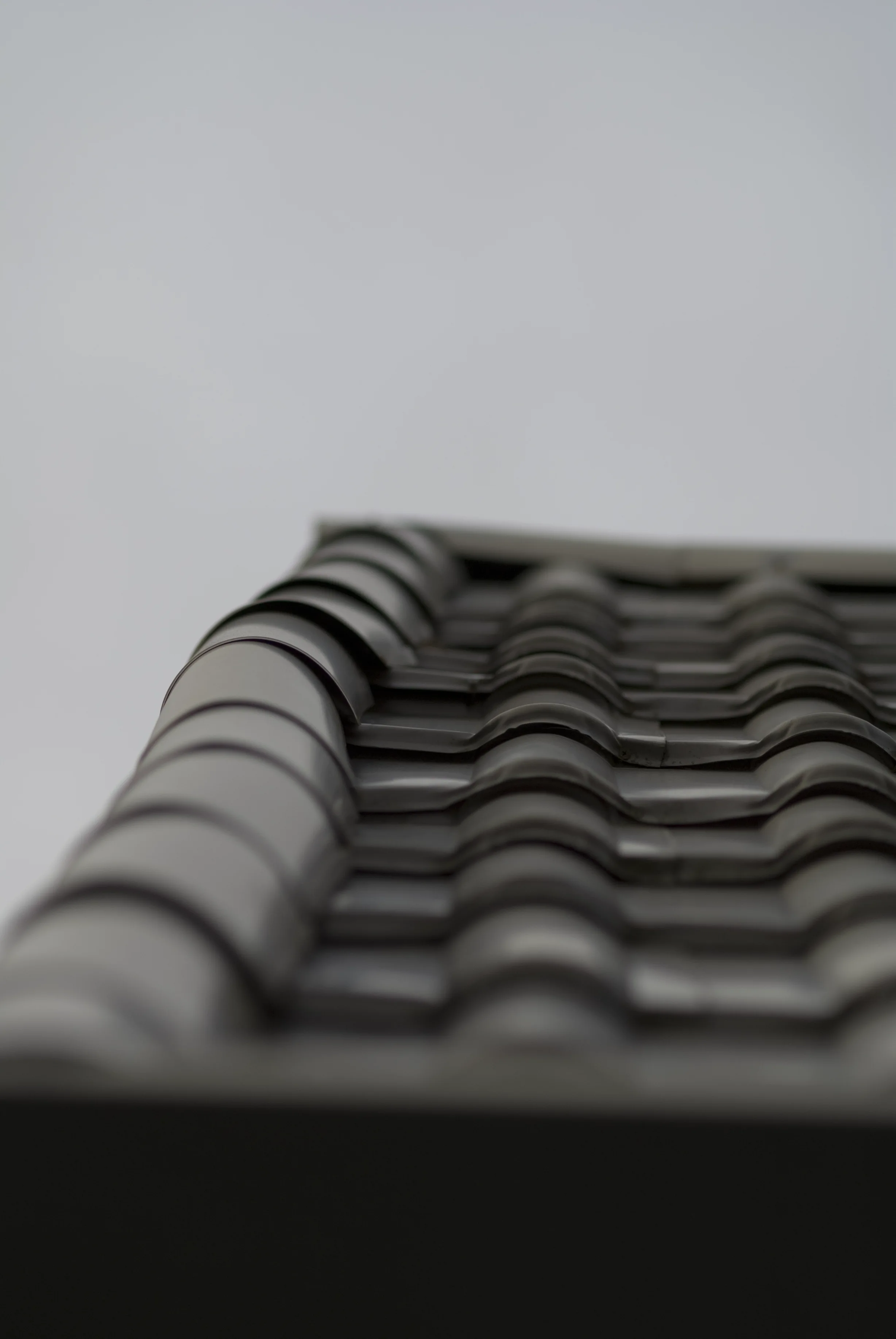 Before: a metal roof with broken tiles on the home, Surrey, British Columbia, ahead of a Black Interlock Slate aluminum roof