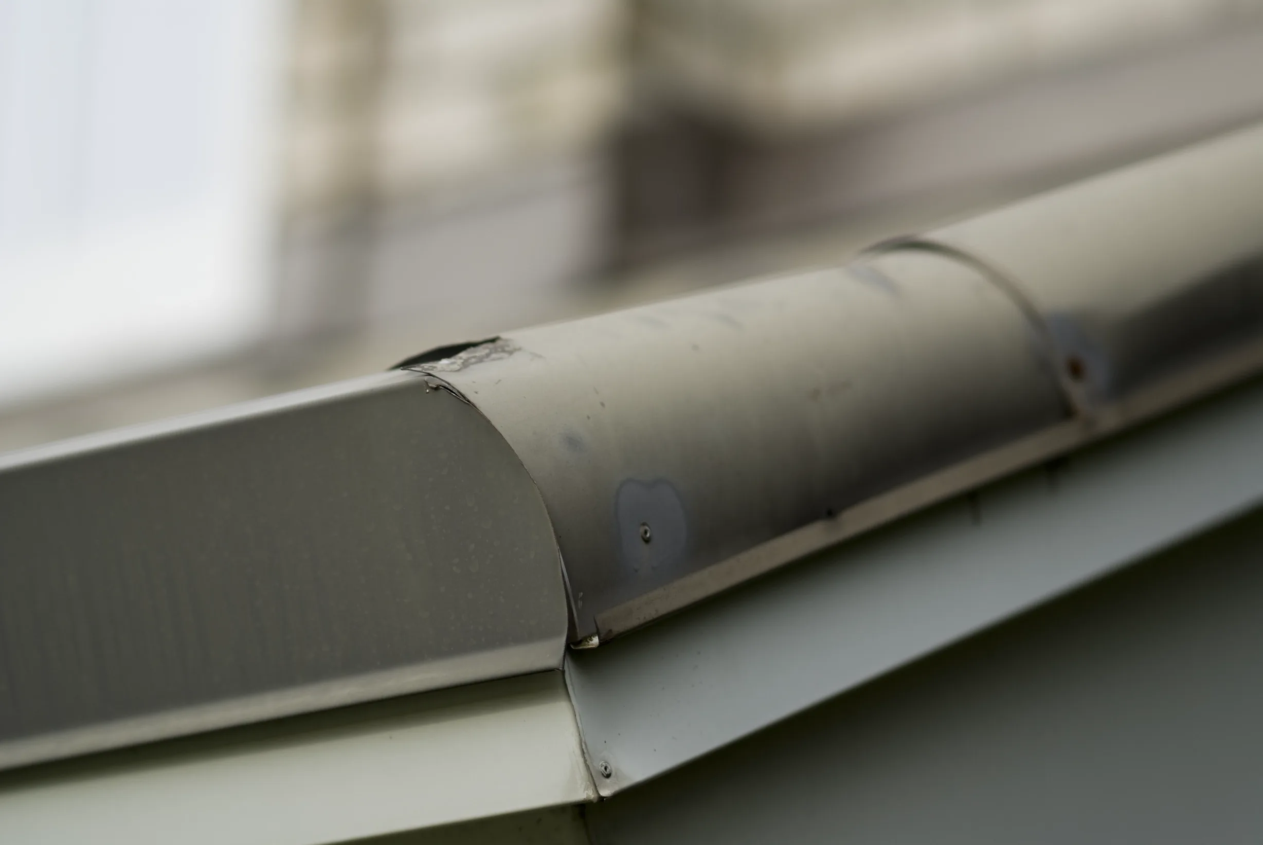 Before: a metal roof with broken tiles on the home, Surrey, British Columbia, ahead of a Black Interlock Slate aluminum roof