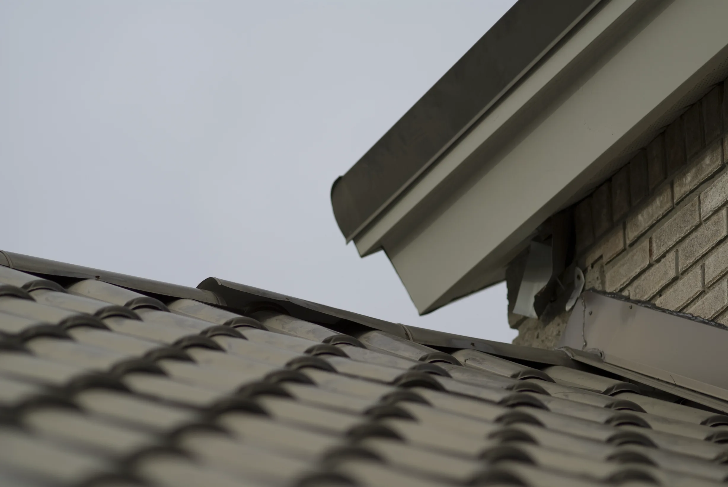 Before: a metal roof with broken tiles on the home, Surrey, British Columbia, ahead of a Black Interlock Slate aluminum roof
