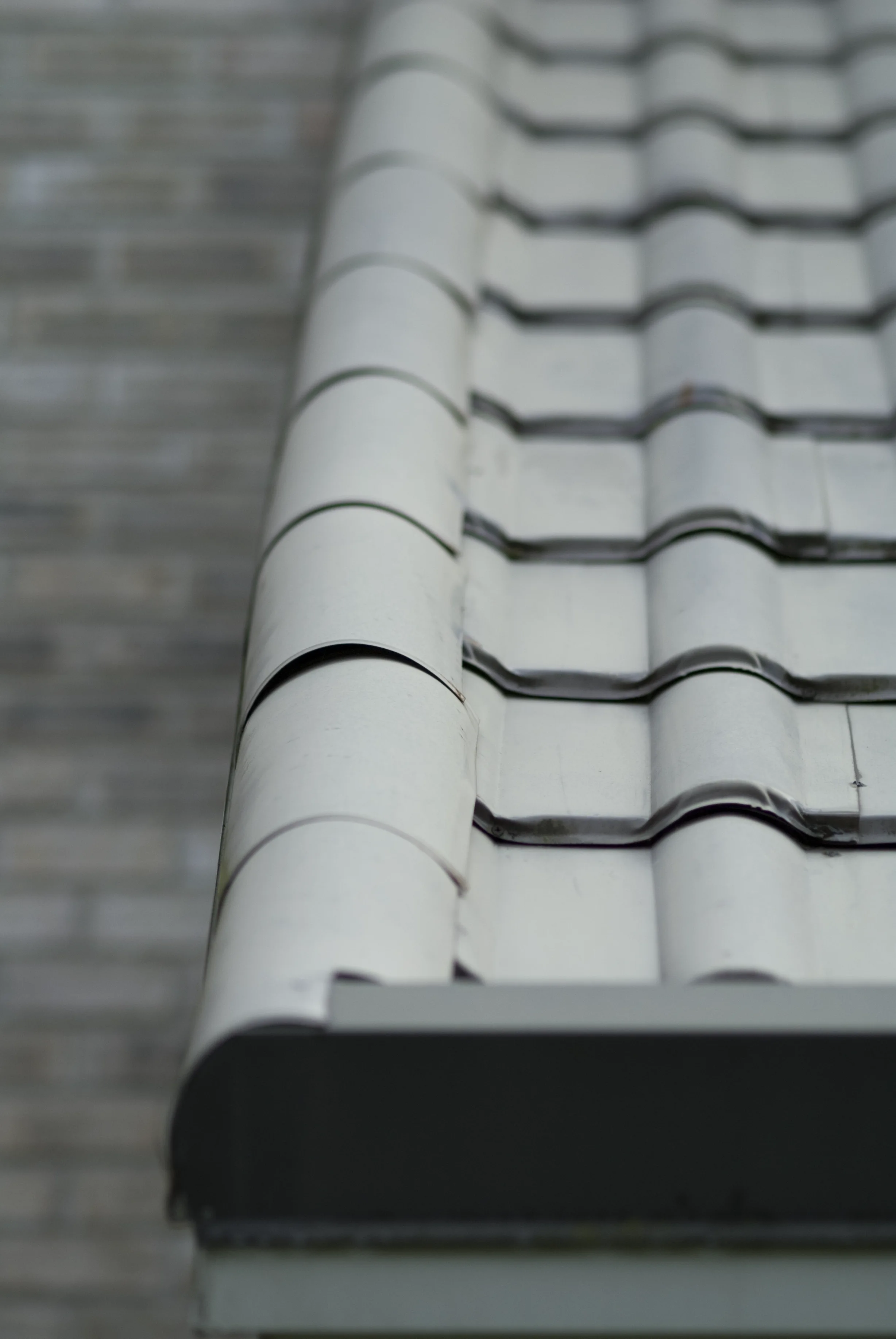 Before: a metal roof with broken tiles on the home, Surrey, British Columbia, ahead of a Black Interlock Slate aluminum roof