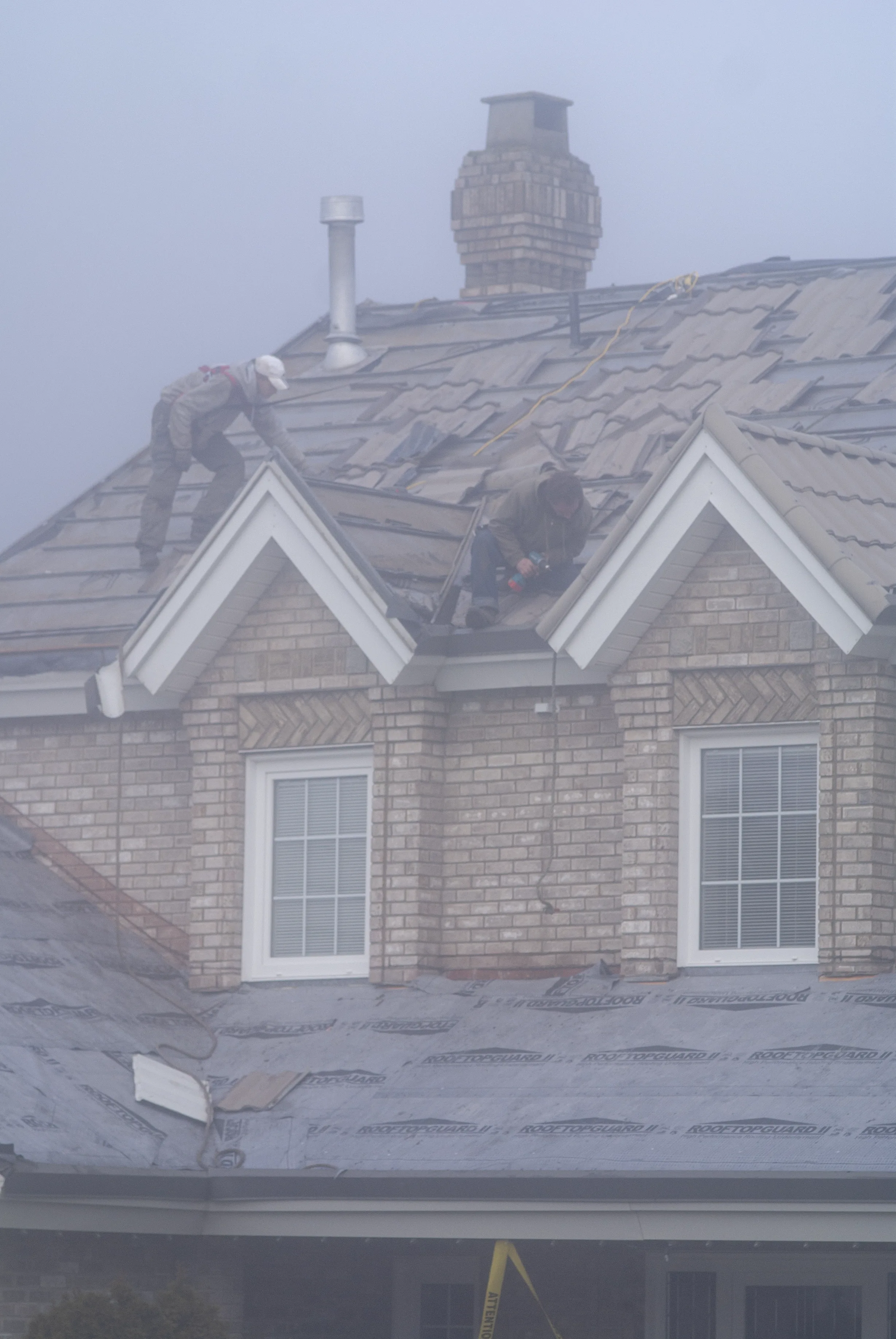 Black Interlock Slate aluminum roof being installed on the home, replacing an asphalt shingle roof being torn off, Surrey, British Columbia