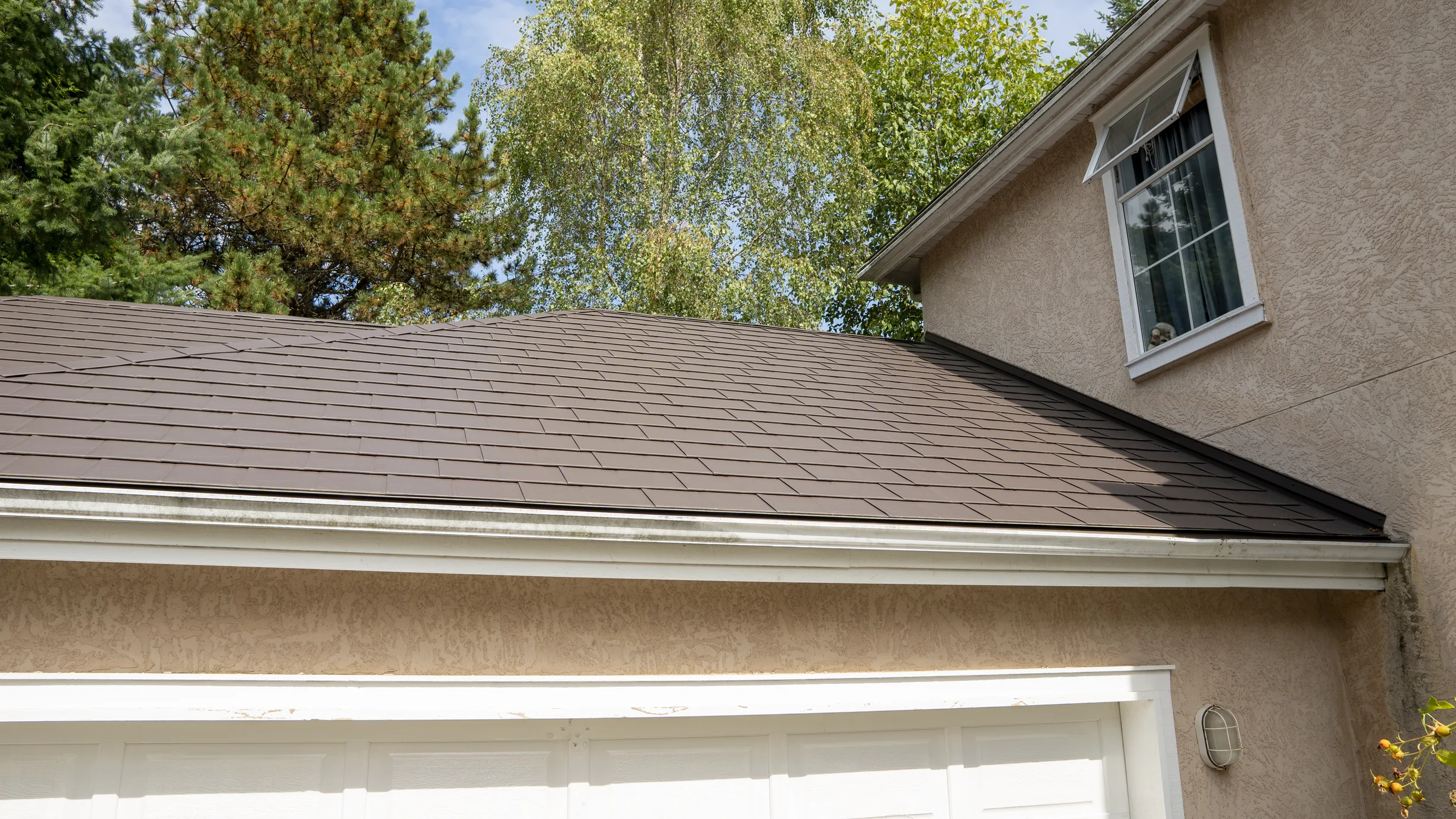 Tudor Brown Interlock Slate aluminum roof on a two-storey Tudor home with dormers in a suburban forest, Surrey, British Columbia