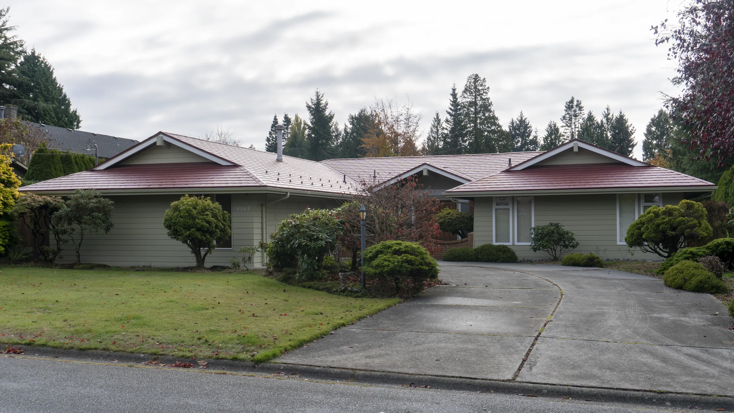 Tile Red Interlock Slate aluminum roof on a ranch home in a suburban setting with lush greenery, Delta, British Columbia
