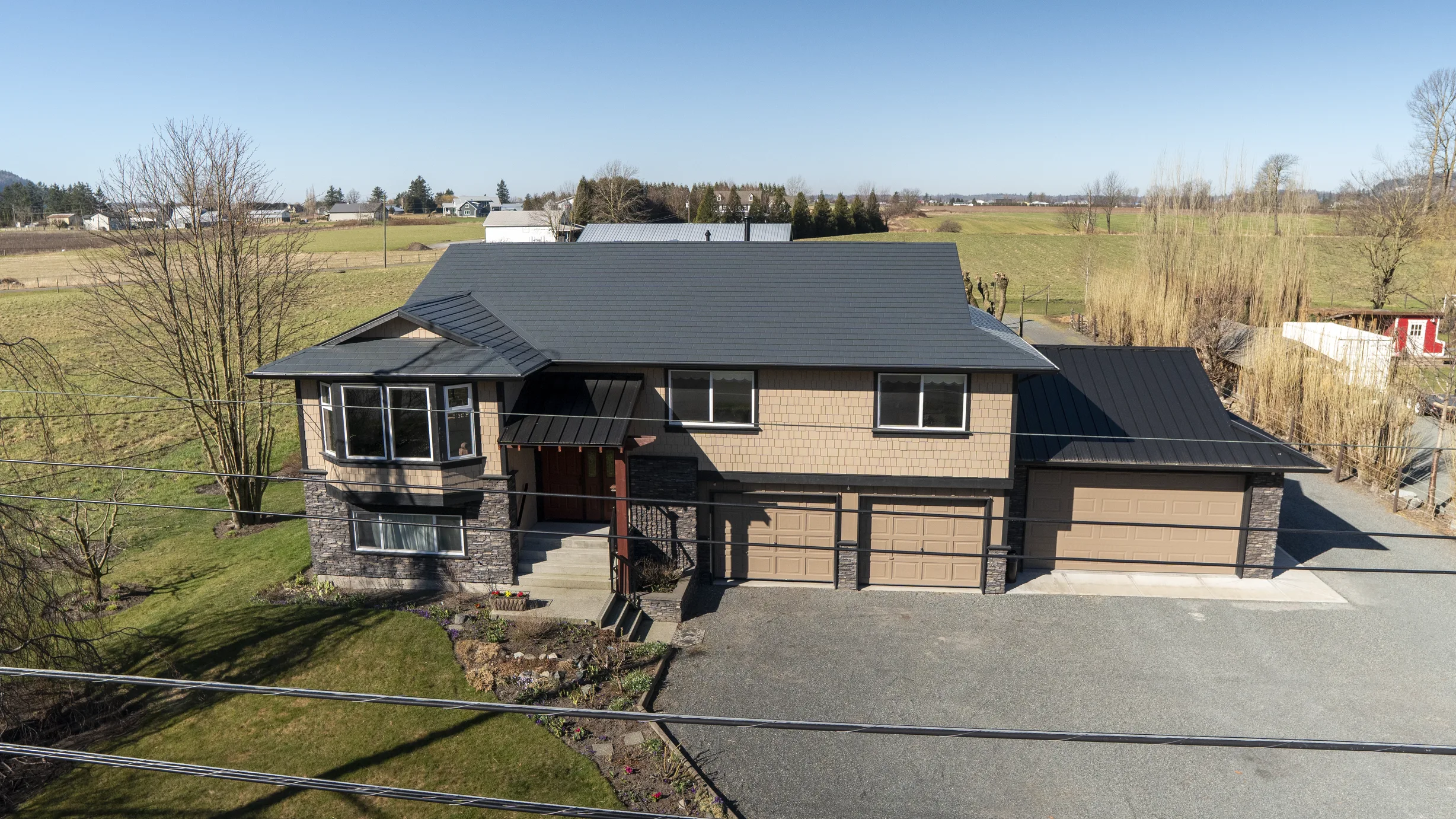 Deep Charcoal Interlock Slate aluminum roof on a two-storey home with a metal roof in a rural setting, Abbotsford, British Columbia