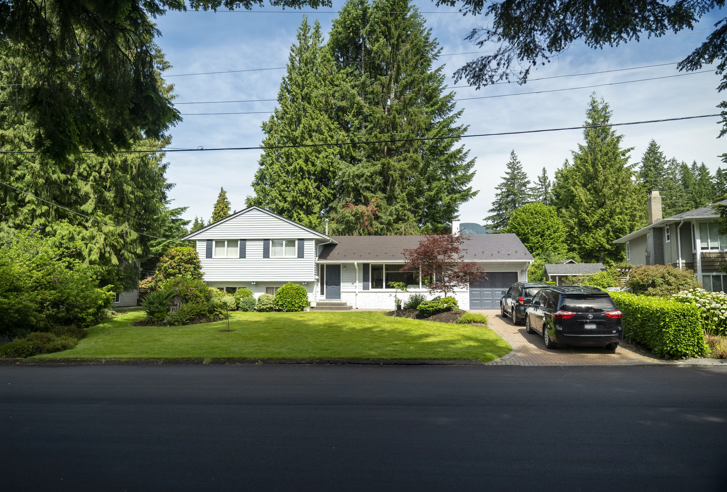 Tudor Brown Interlock Slate aluminum roof on a two-storey Tudor home with dormers and a dark metal roof, North Vancouver, British Columbia