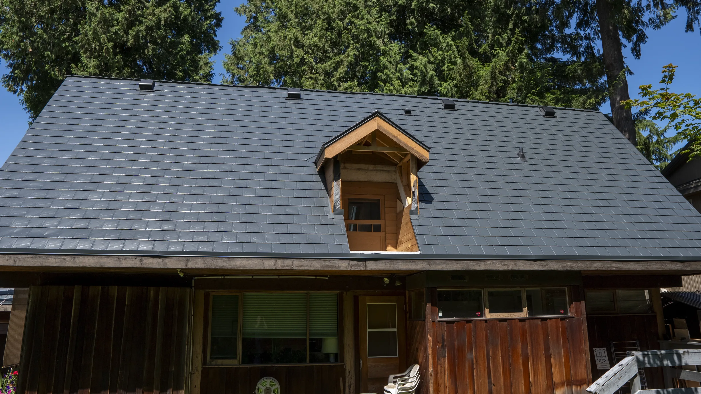 Deep Charcoal Interlock Slate aluminum roof on a modern home with a deep charcoal metal roof in a forested, Burnaby, British Columbia
