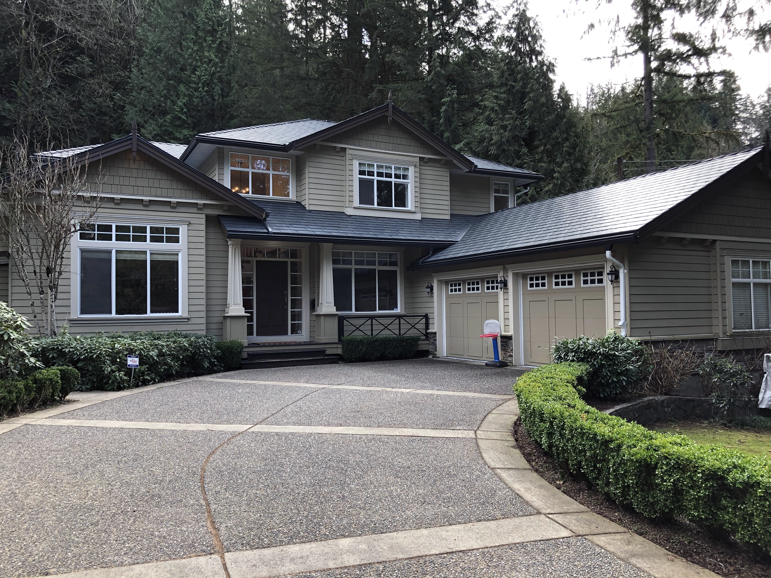 Two-story Craftsman home in North Vancouver with Interlock deep charcoal aluminum slate metal roofing featuring a multi-plane complex roof and covered front entry.