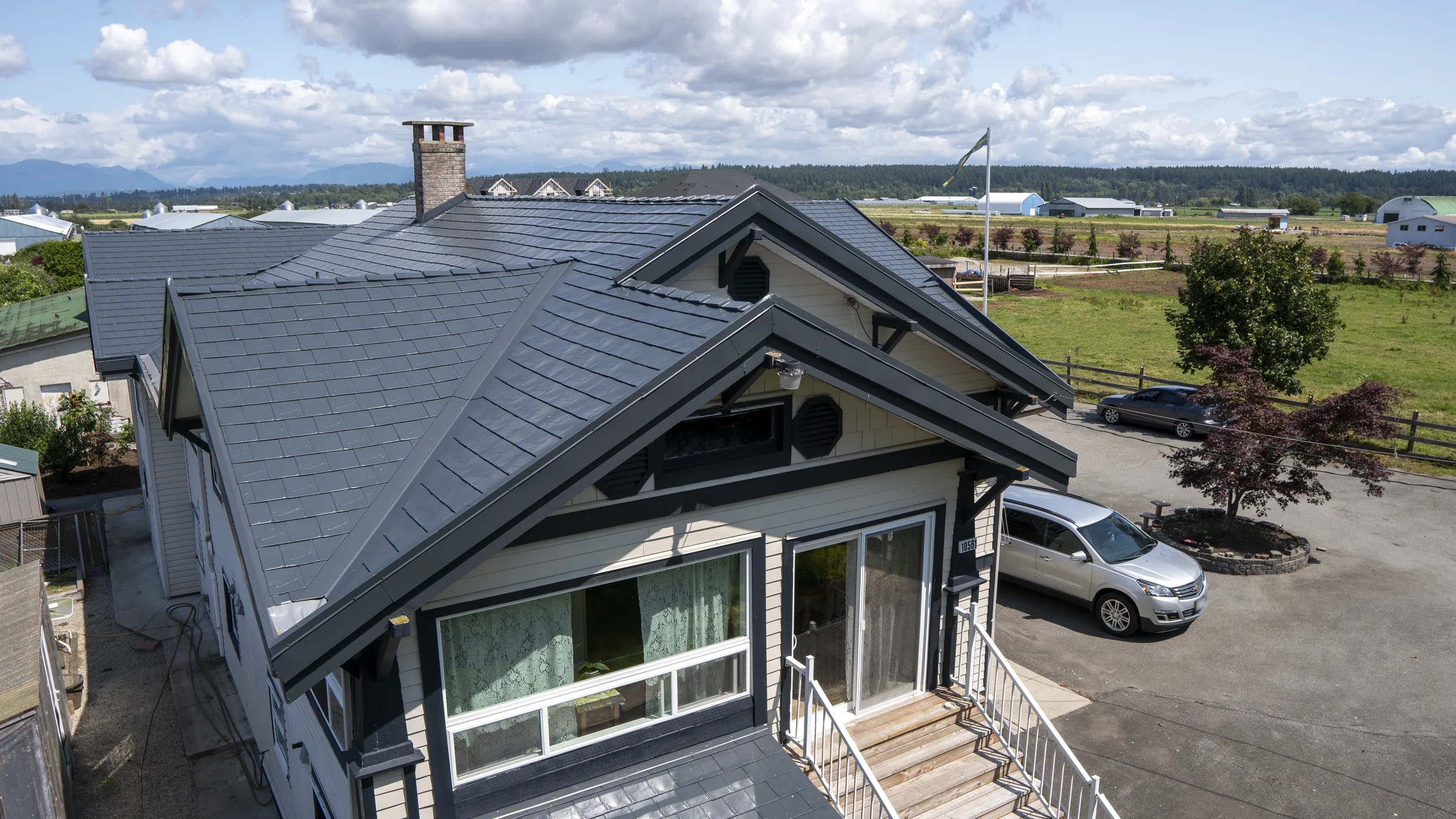 Deep Charcoal Interlock Slate aluminum roof on a single-storey home with a metal roof in a rural setting, Delta, British Columbia