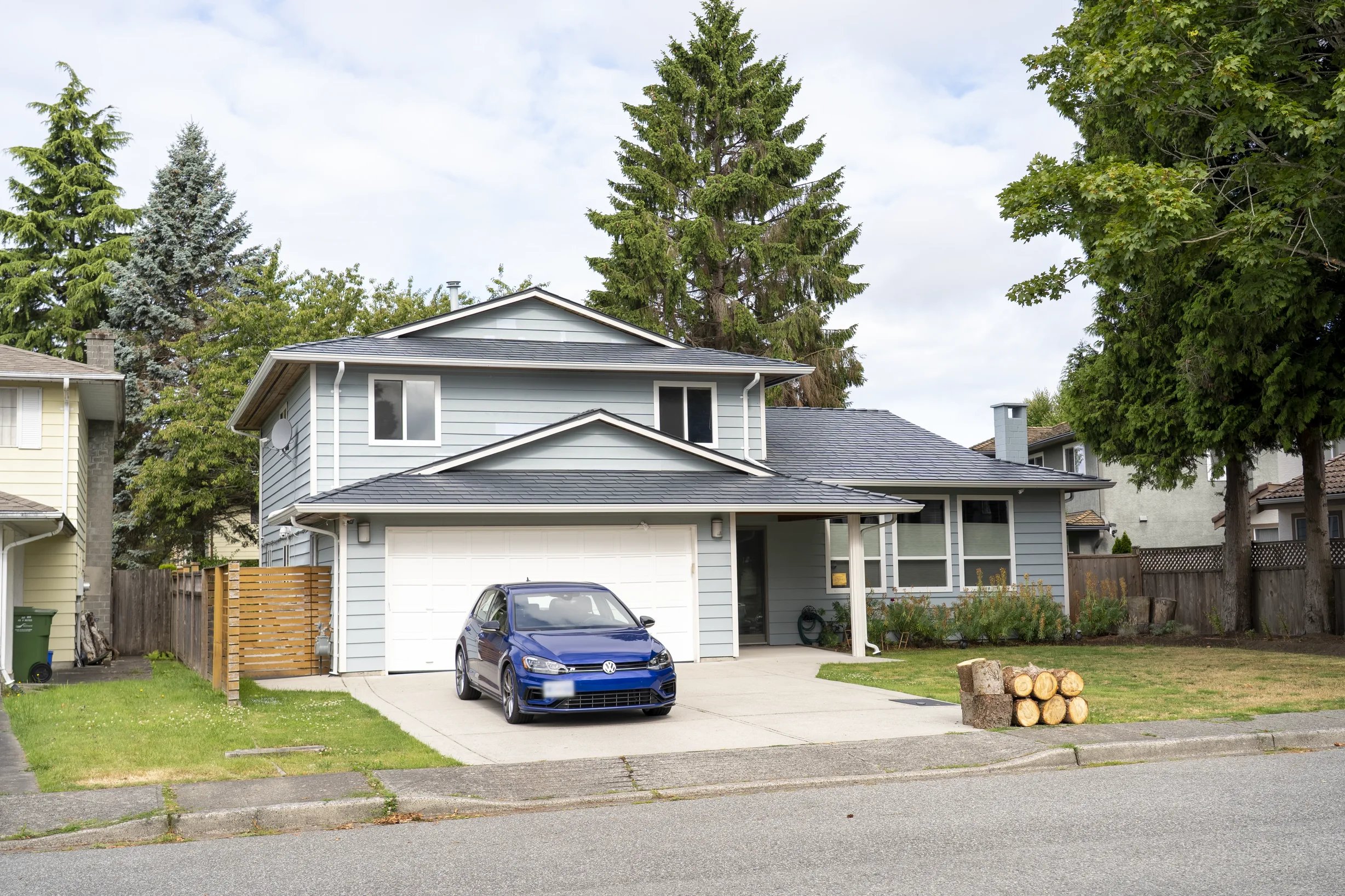 Deep Charcoal Interlock Slate aluminum roof on a two-storey home with a metal roof in a suburban forest, Richmond, British Columbia