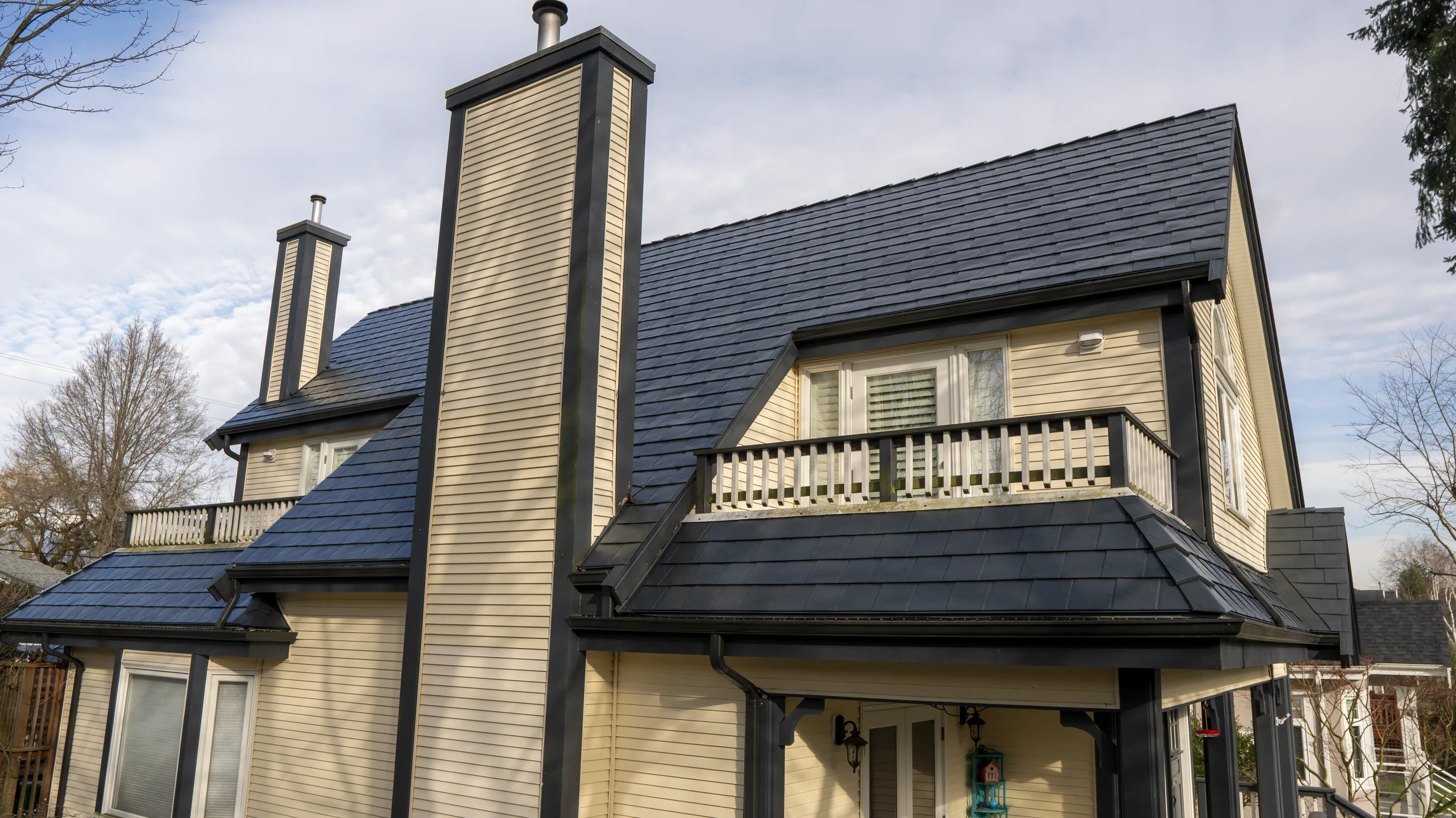 Deep Charcoal Interlock Slate aluminum roof on a beige single-storey craftsman home with a balcony among, Vancouver, British Columbia