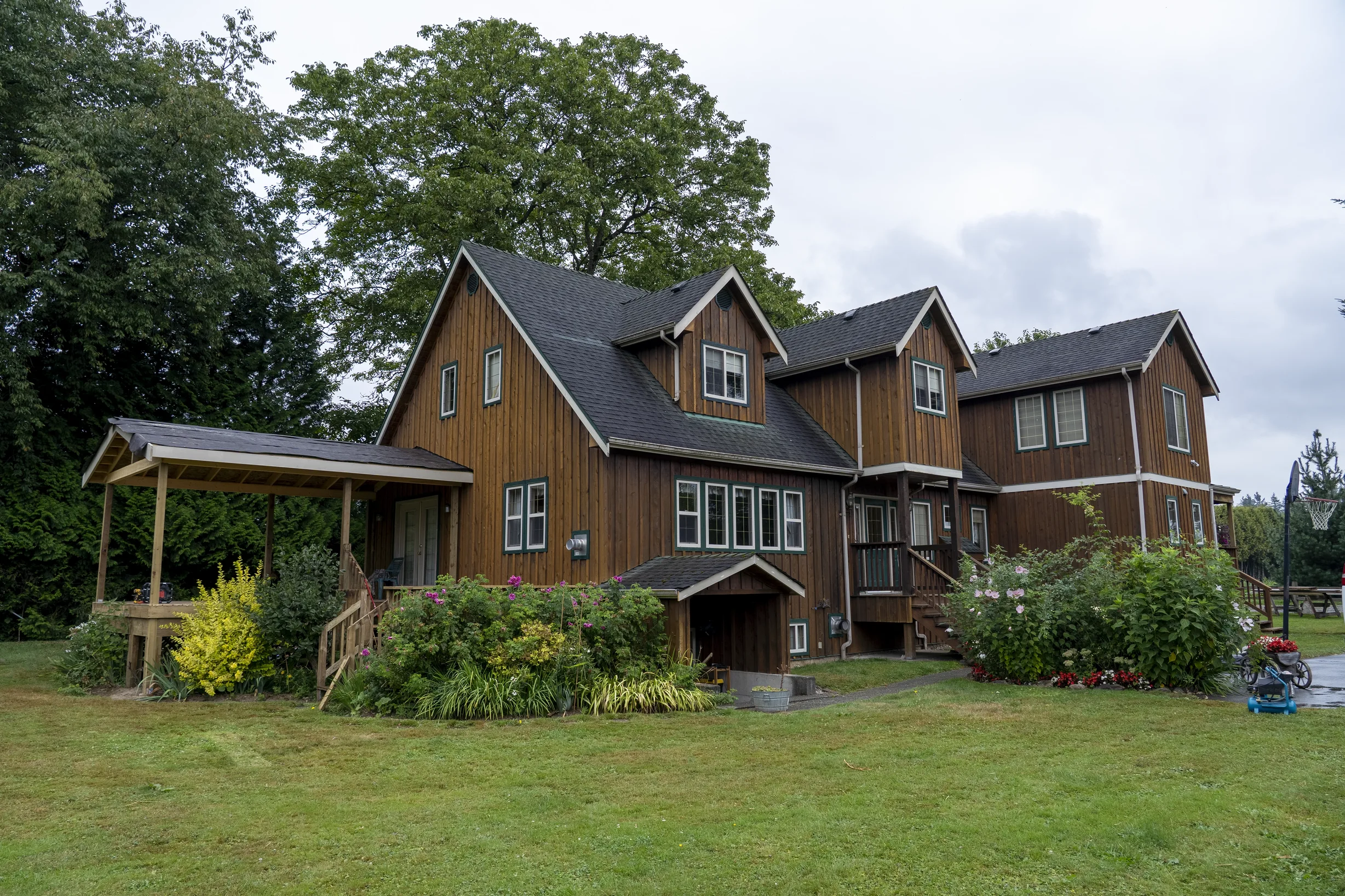 Hunter Green Interlock Slate aluminum roof on a brown two-storey home with dormers on a rural property, Langley, British Columbia