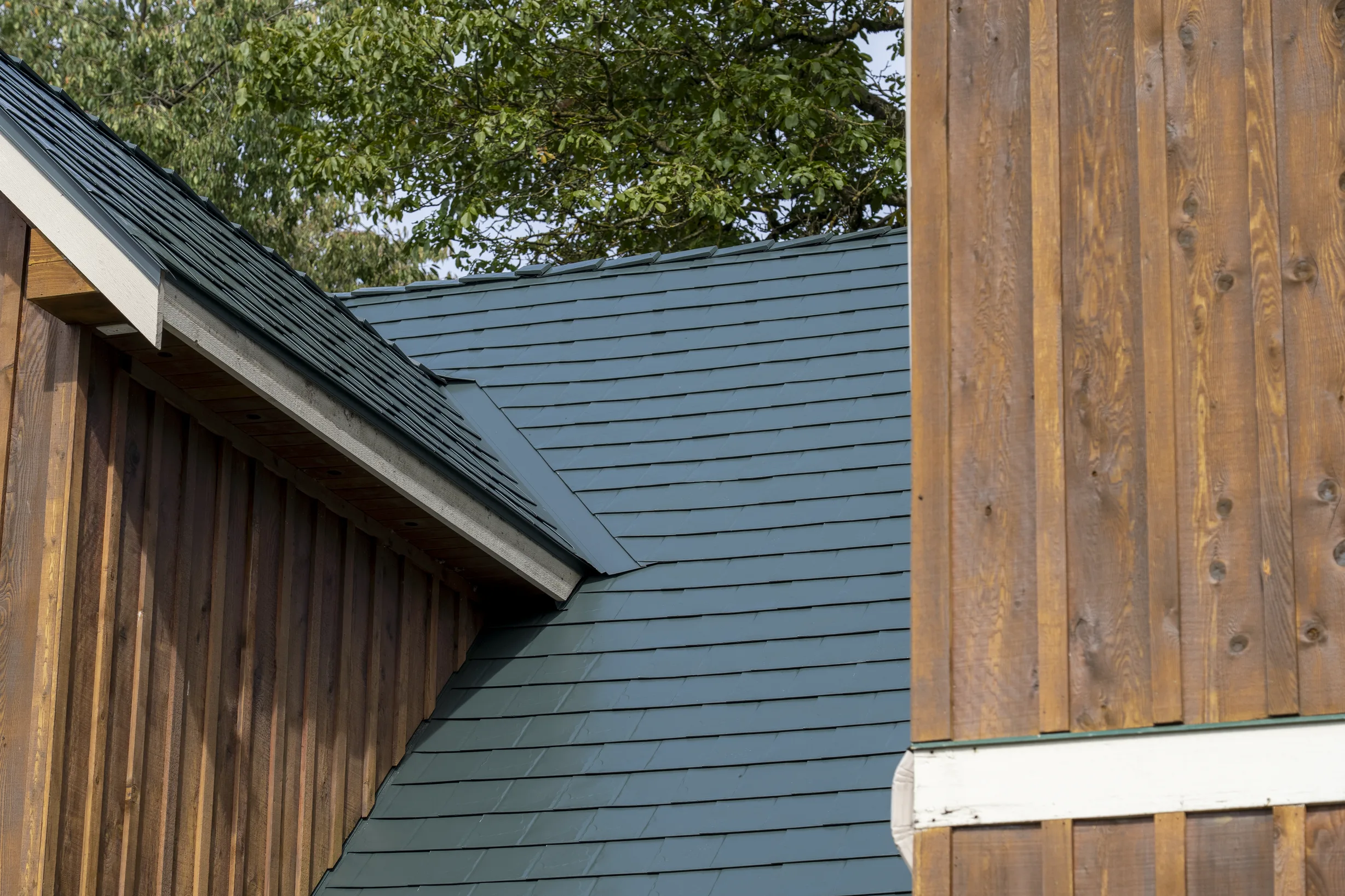 Hunter Green Interlock Slate aluminum roof on a green house with a hunter green metal roof in a wooded, Langley, British Columbia