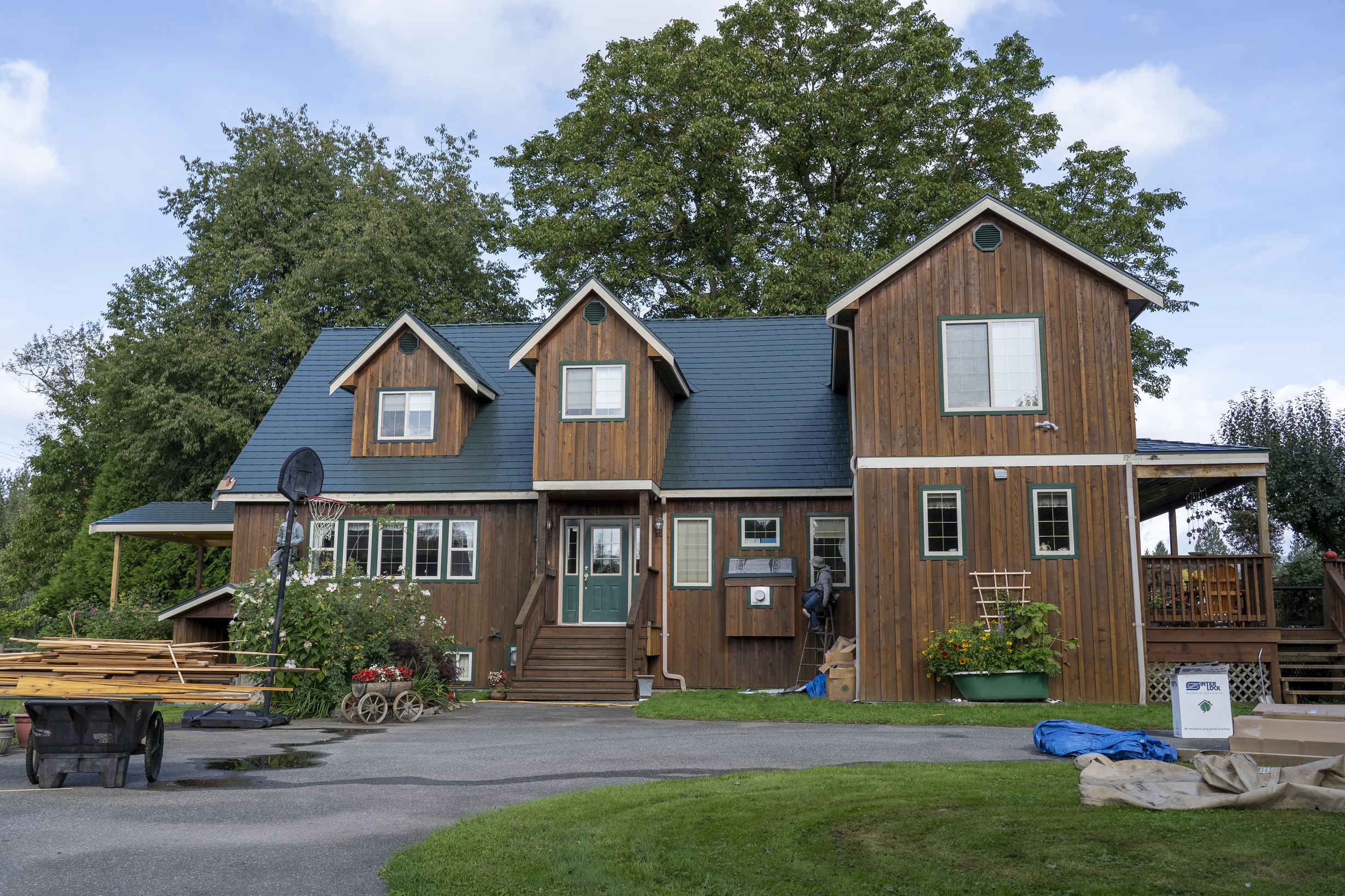 Hunter Green Interlock Slate aluminum roof on a brown two-storey home with a hunter green metal roof in, Langley, British Columbia
