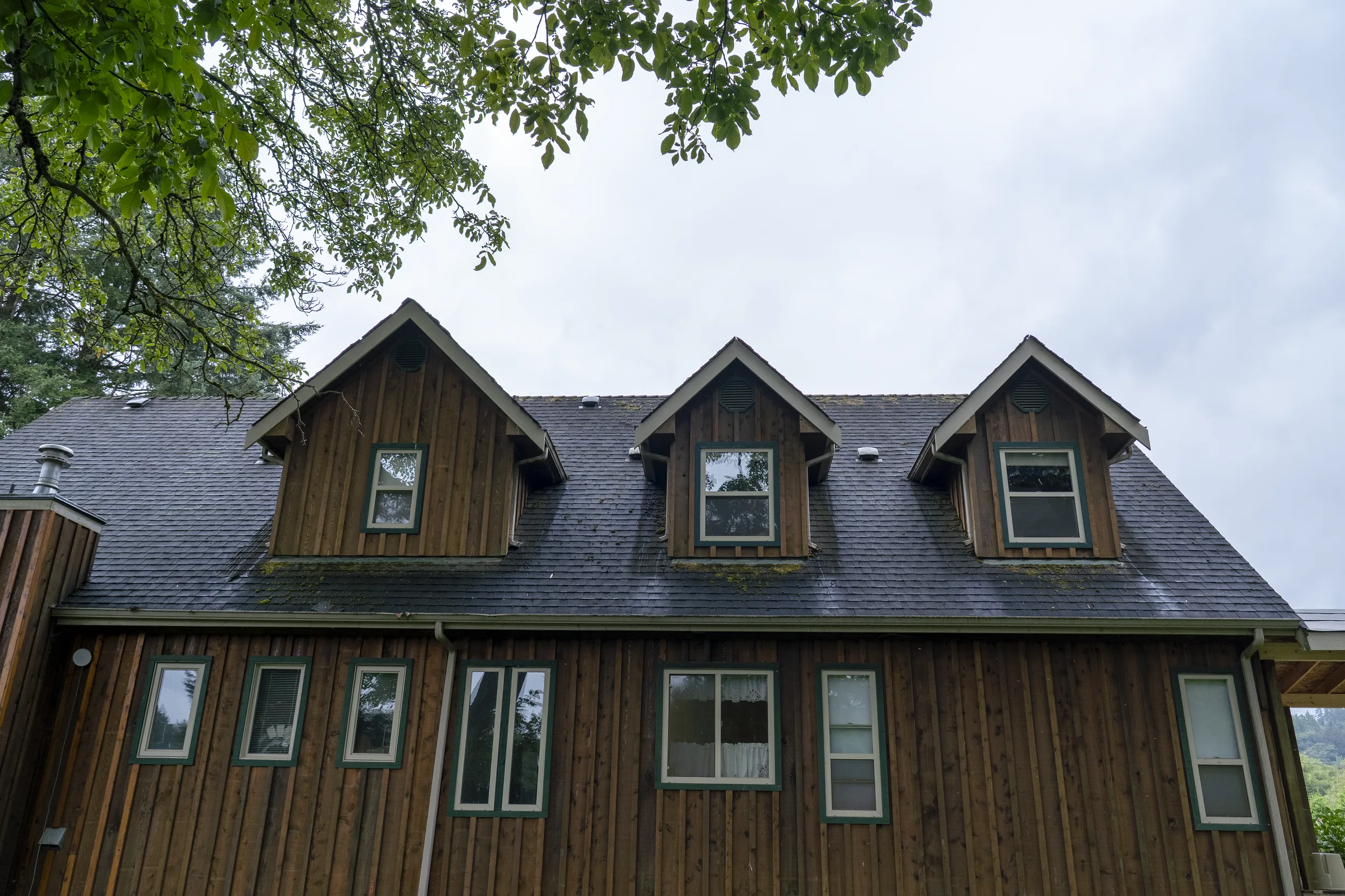Hunter Green Interlock Slate aluminum roof on a modern home with a hunter green metal roof in a forested, Langley, British Columbia