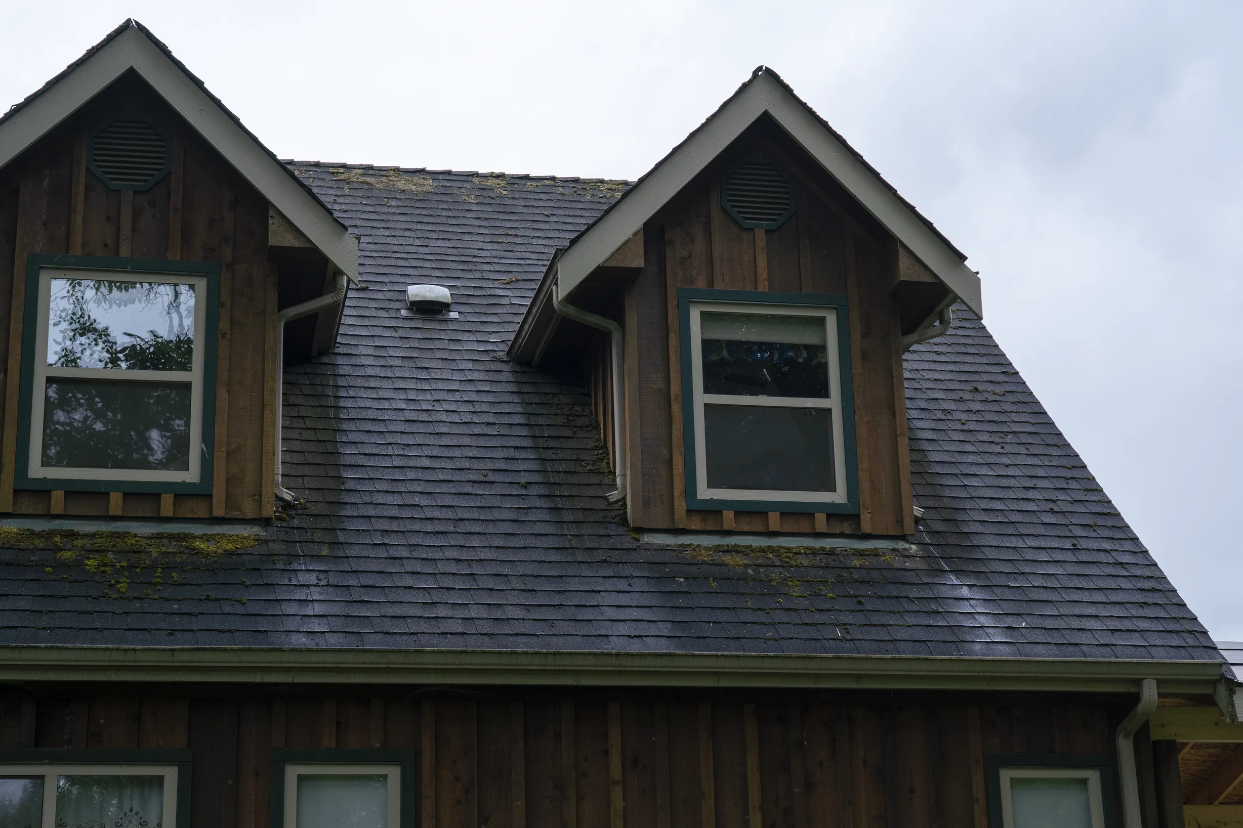 Before: a mossy asphalt shingle roof on the home, Langley, British Columbia, ahead of a Hunter Green Interlock Slate aluminum roof