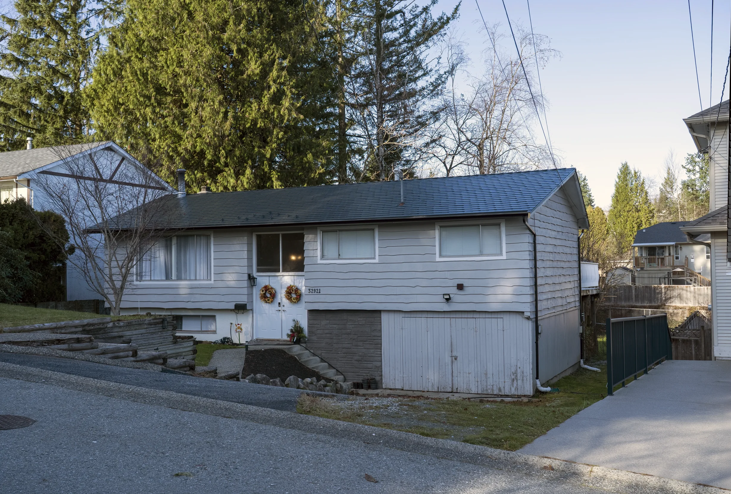 Deep Charcoal Interlock Slate aluminum roof on a grey one-storey home with dormers in a suburban setting, Mission, British Columbia