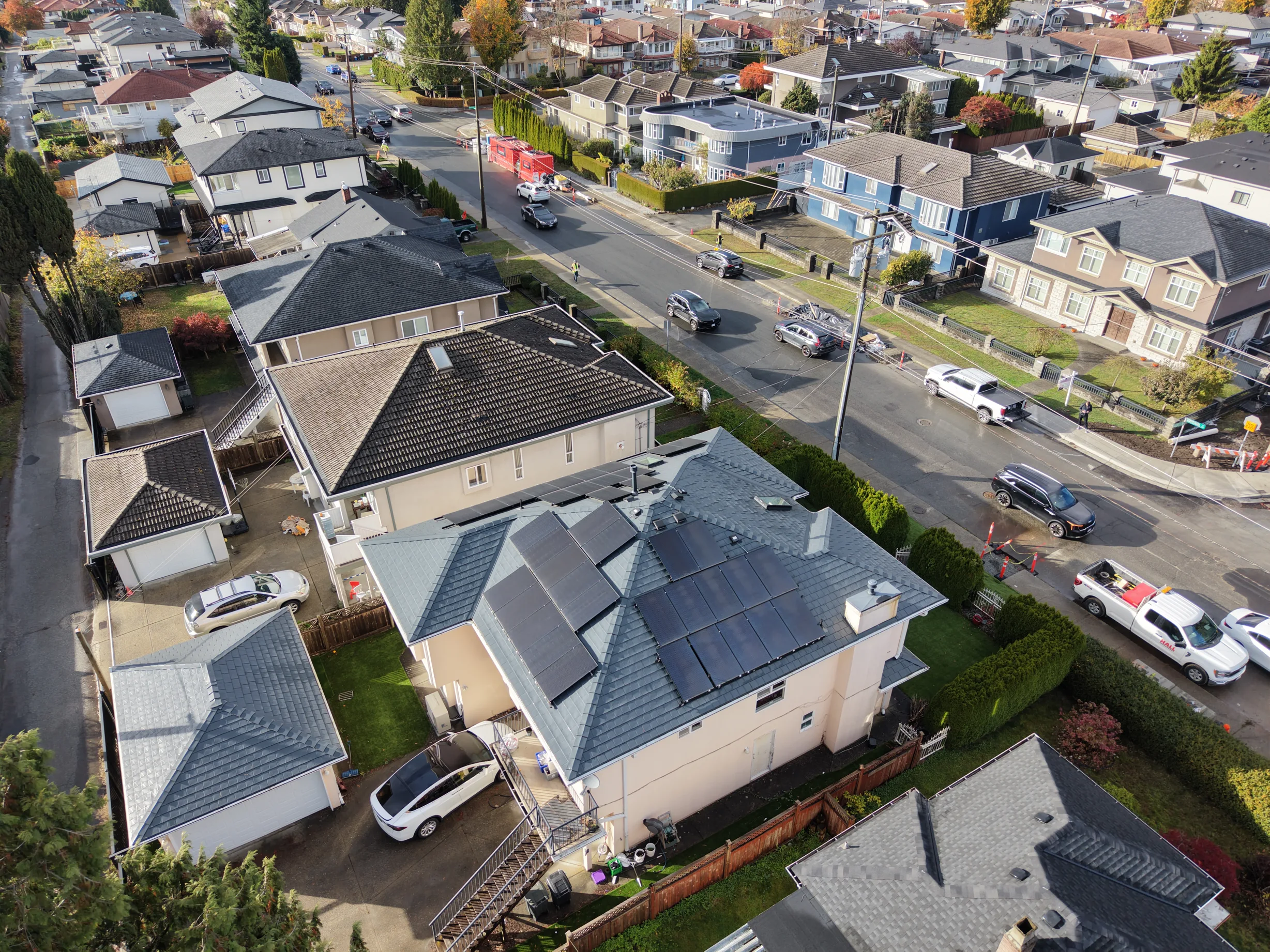 Deep Charcoal Interlock Slate aluminum roof on a beige two-storey home with dormers in a suburban setting, Burnaby, British Columbia