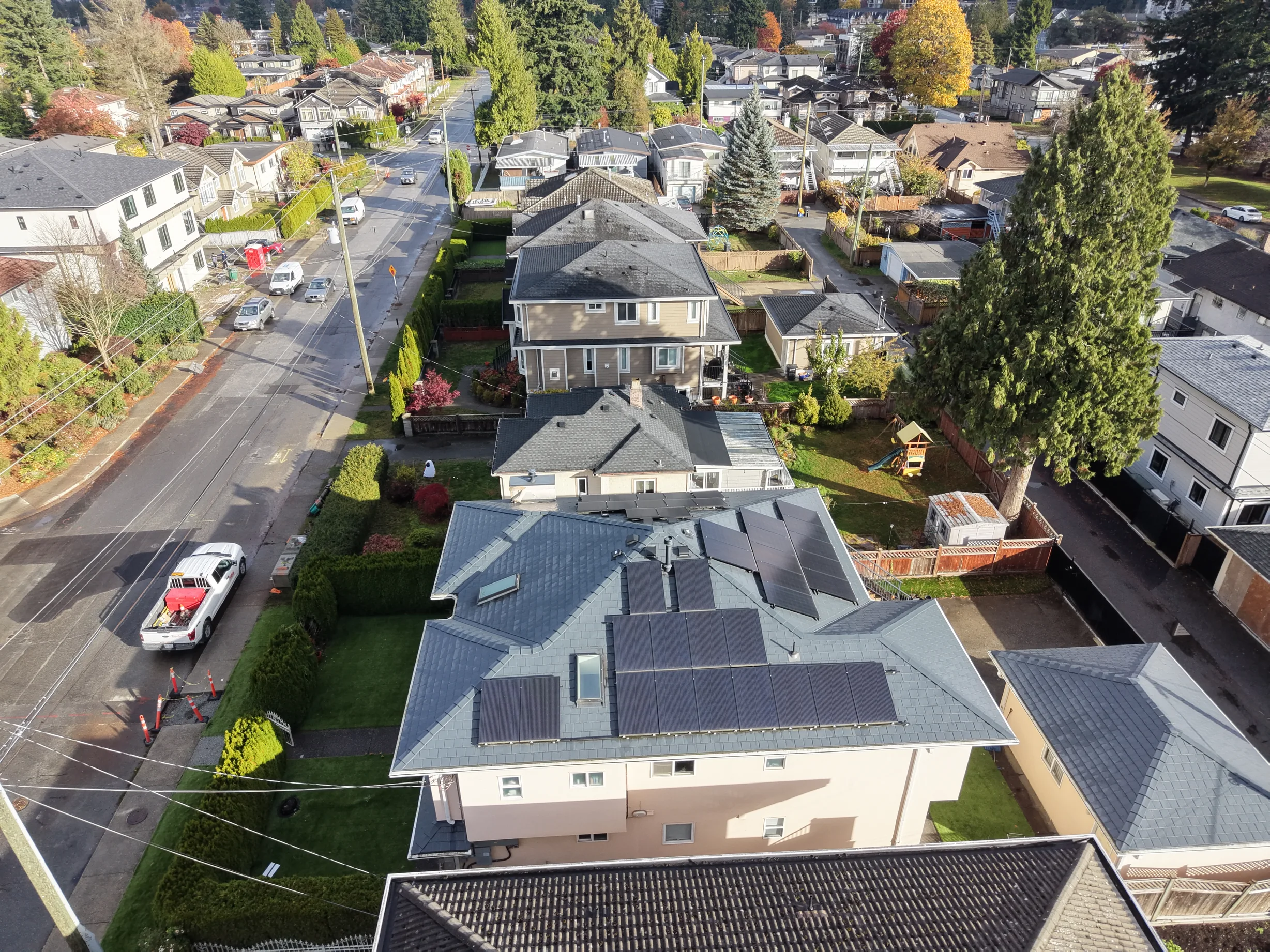 Deep Charcoal Interlock Slate aluminum roof on a beige single-storey home with a metal roof in a forested, Burnaby, British Columbia