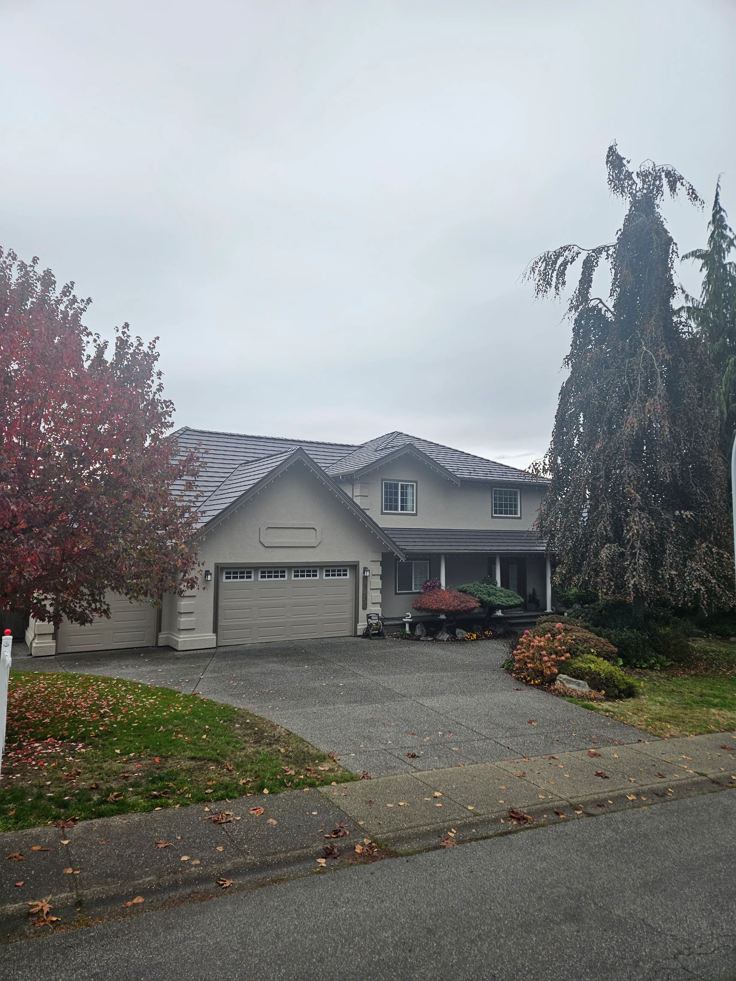 Tudor Brown Interlock Shake aluminum roof on a grey two-storey Tudor home with dormers and a Tudor Brown, Surrey, British Columbia