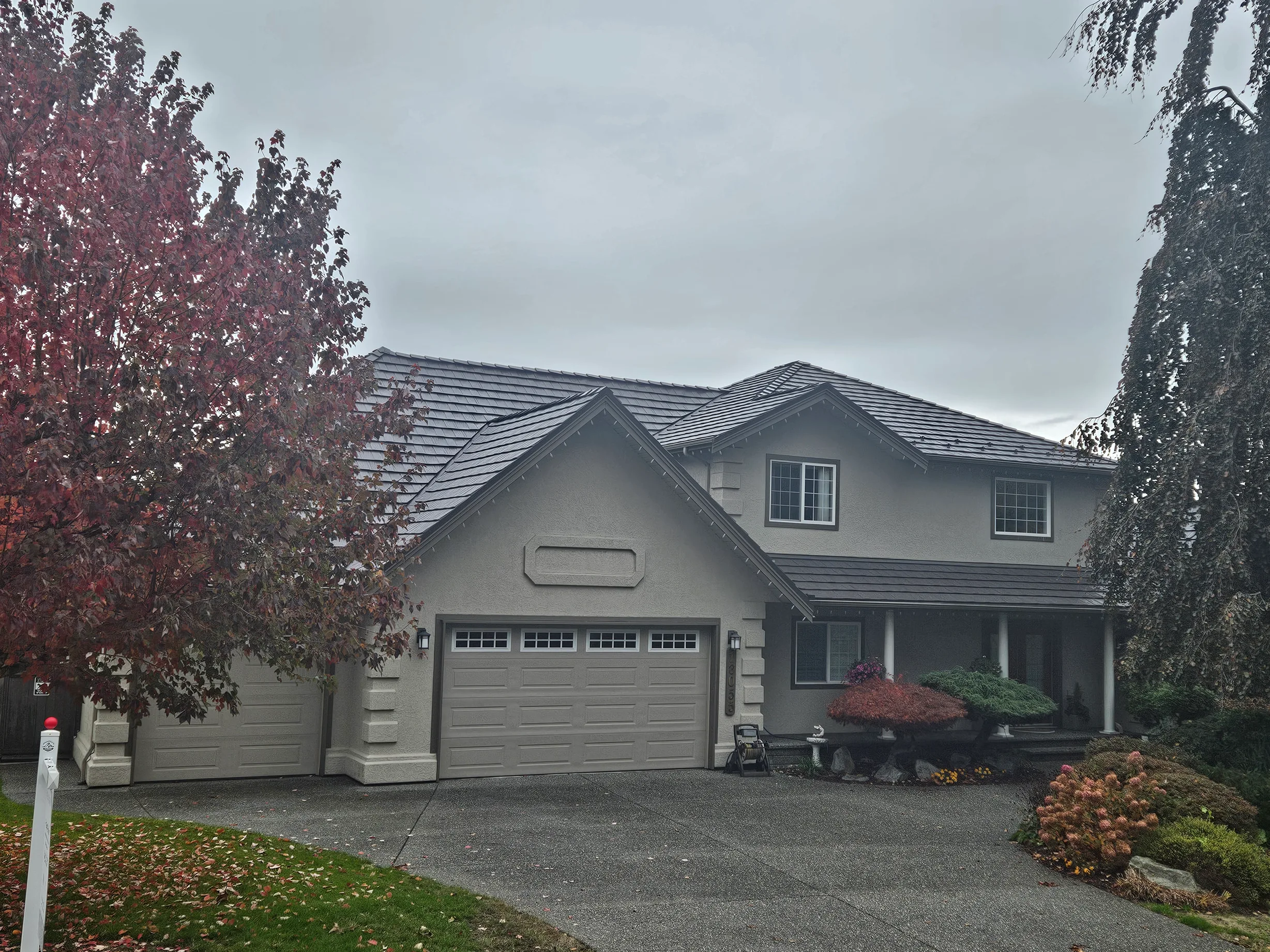 Tudor Brown Interlock Shake aluminum roof on a grey two-storey Tudor home with a Tudor Brown metal roof, Surrey, British Columbia