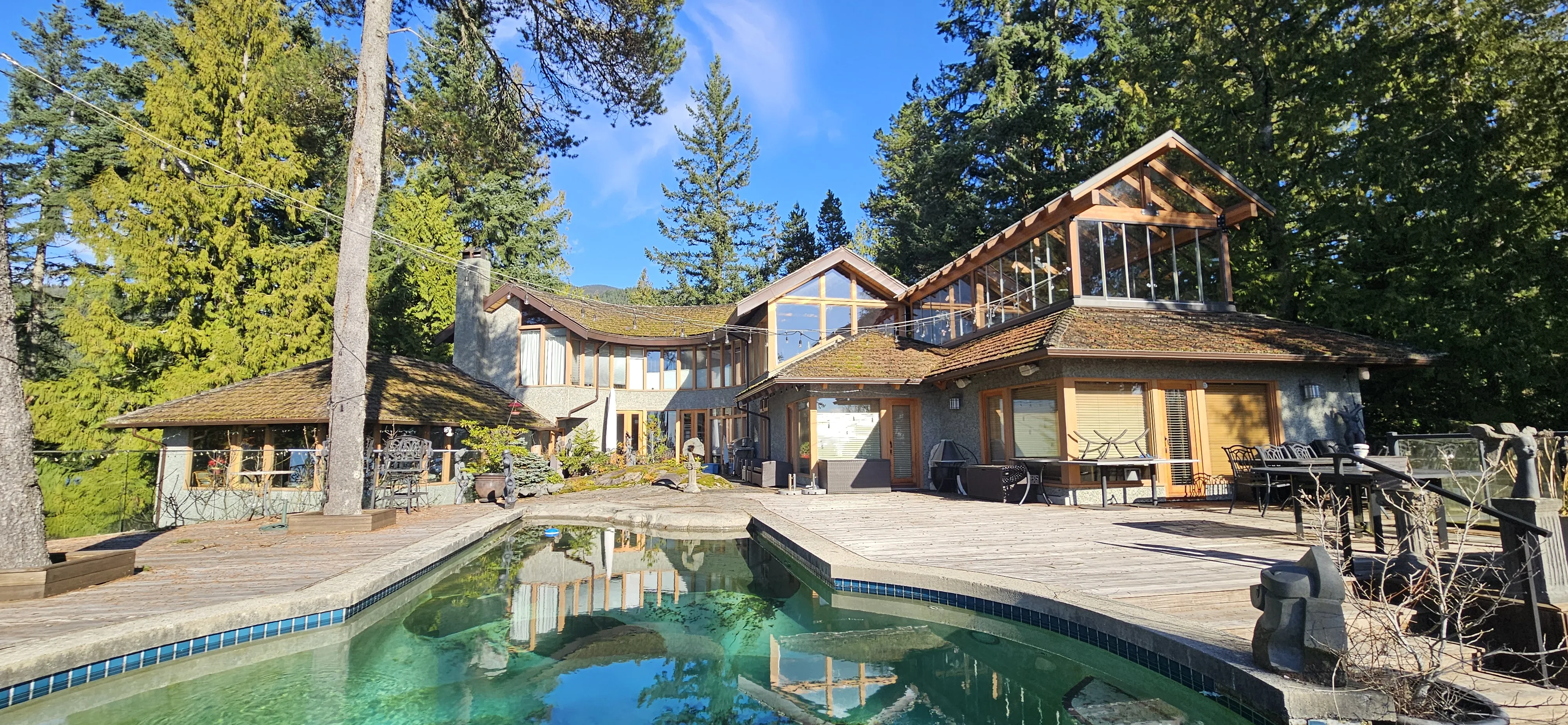 Wide-angle, level view of the aging cedar shake roof on a West Vancouver, BC home prior to its Interlock metal roof replacement.