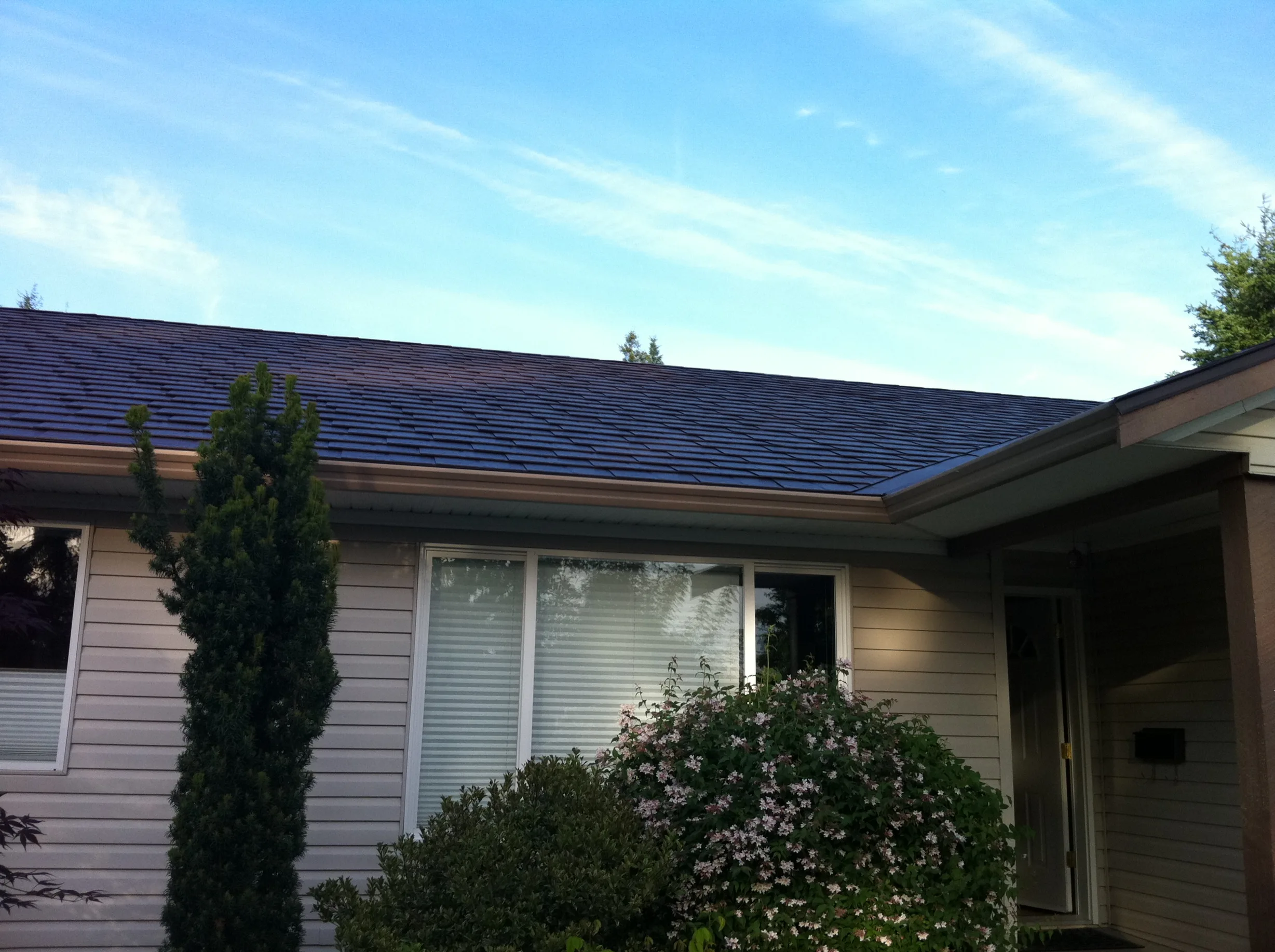 Colonial Brown Interlock Slate aluminum roof on a tan single-family home with a Colonial roof in a rural, Campbell River, British Columbia