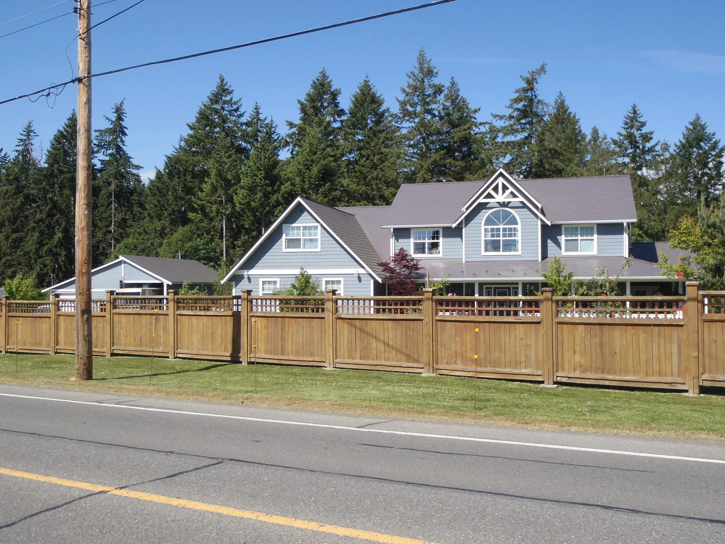 Weathered Interlock Slate aluminum roof on a two-storey home with grey metal roof and a fence among, Duncan, British Columbia
