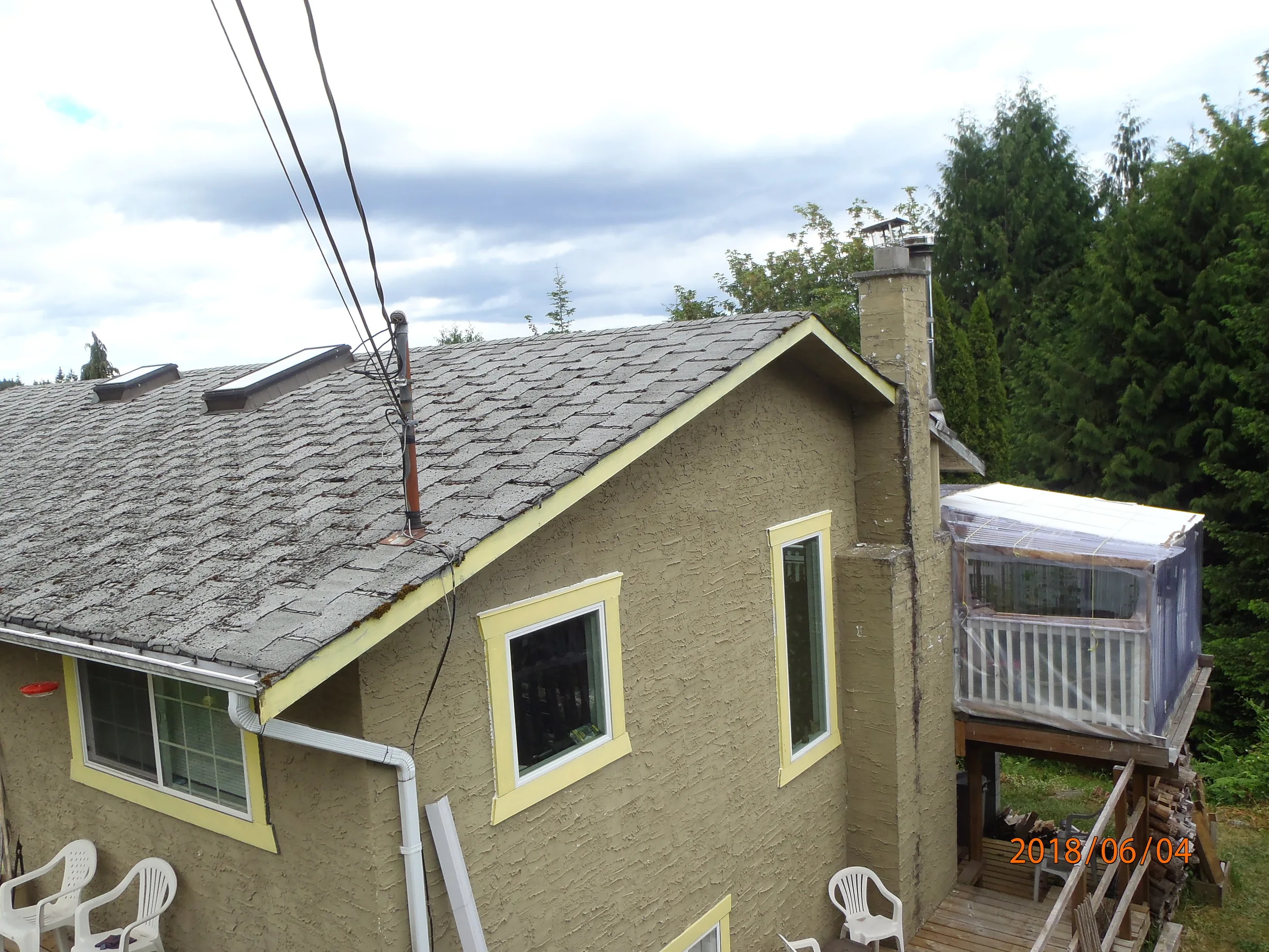 Before: a leaking asphalt shingle roof on the home, Ladysmith, British Columbia, ahead of a Deep Charcoal Interlock Slate aluminum roof