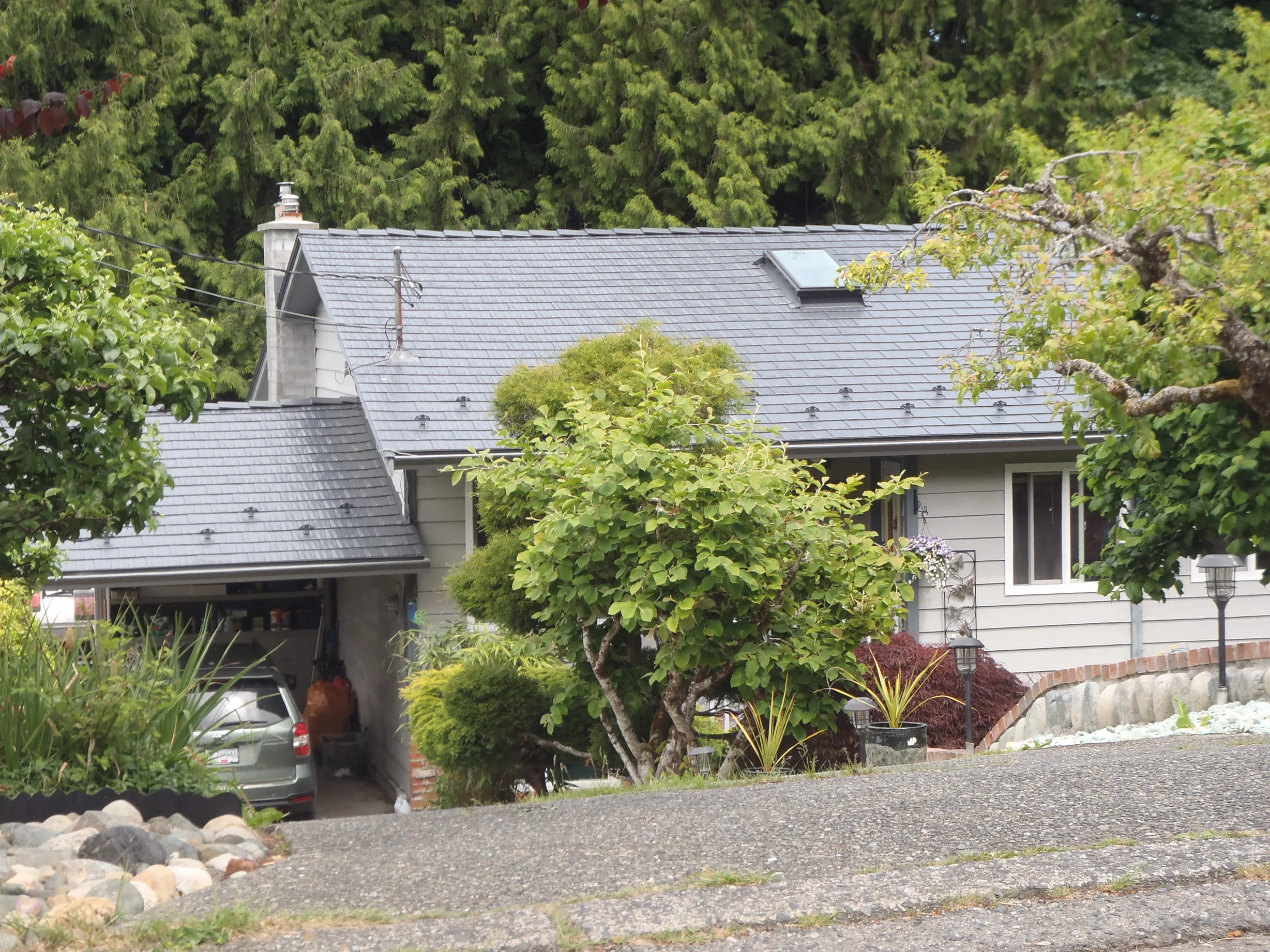 Deep Charcoal Interlock Cedar Shingle aluminum roof on a Deep Charcoal metal roof on a cottage in a forested rural, Ladysmith, British Columbia