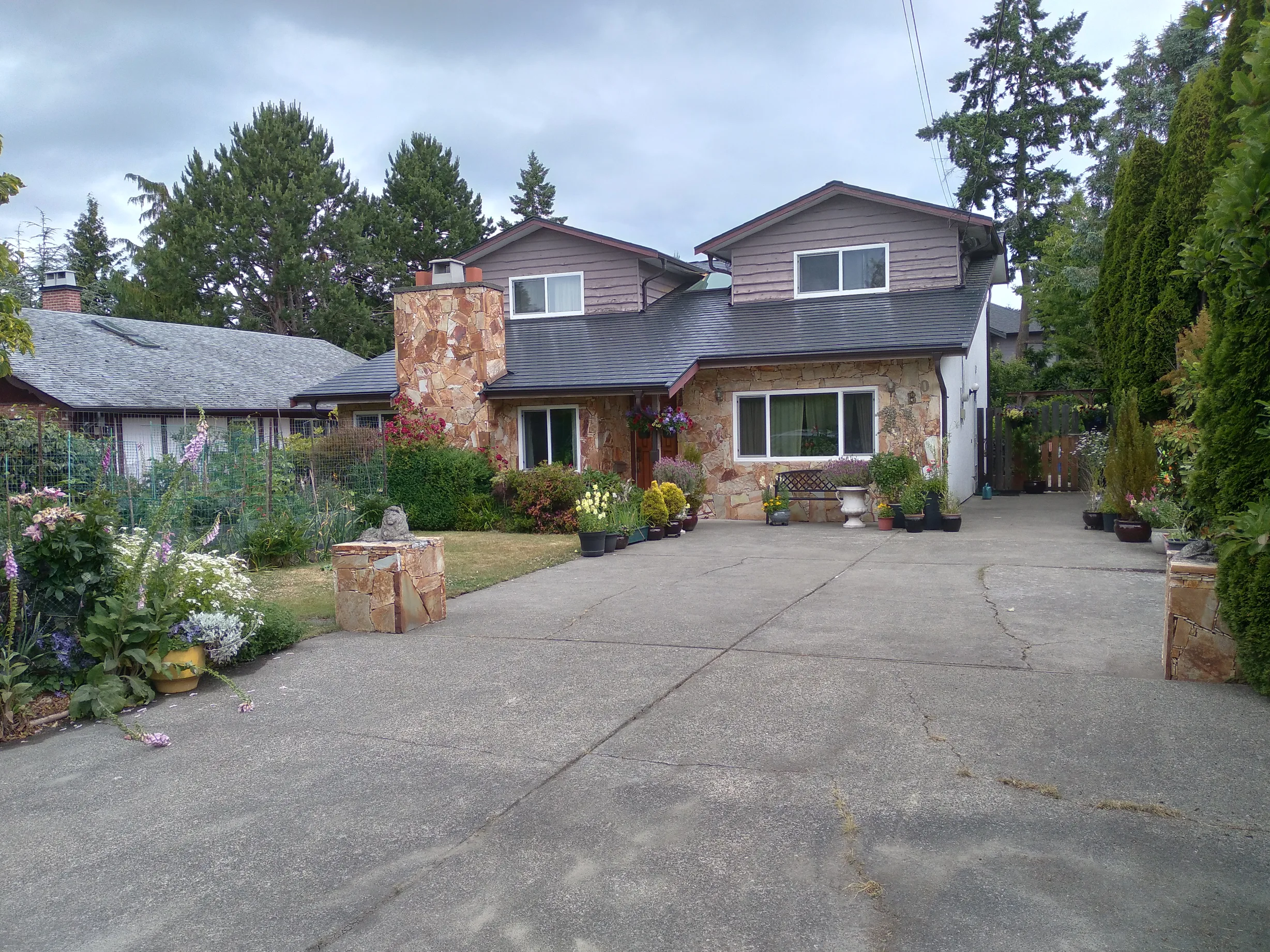 Black Interlock Slate aluminum roof on a house with a brown metal roof and stone facade in a, Victoria, British Columbia