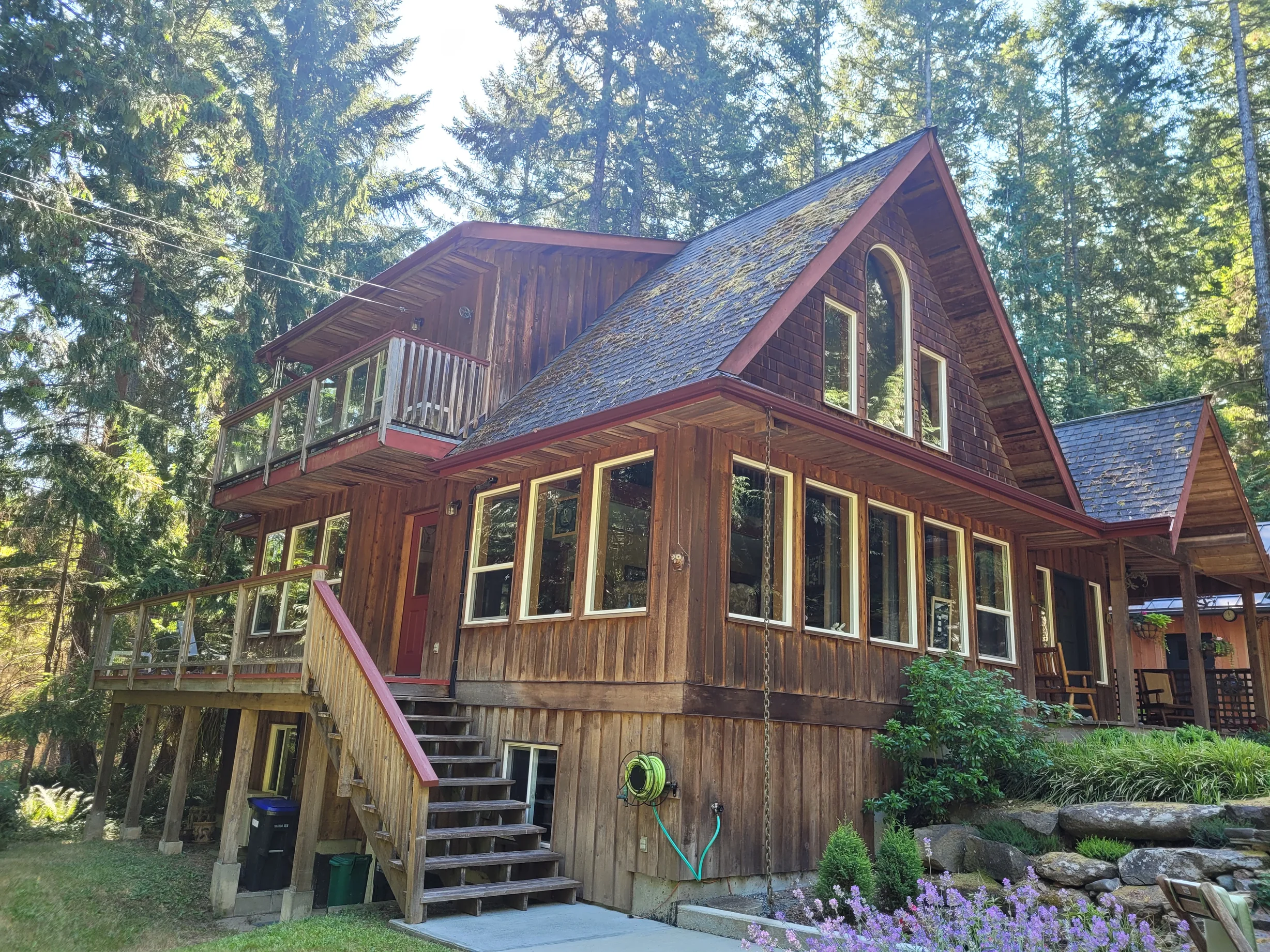 Deep Charcoal Interlock Slate aluminum roof on a brown chalet with a metal roof in a forested lakeside, Gabriola Island, British Columbia