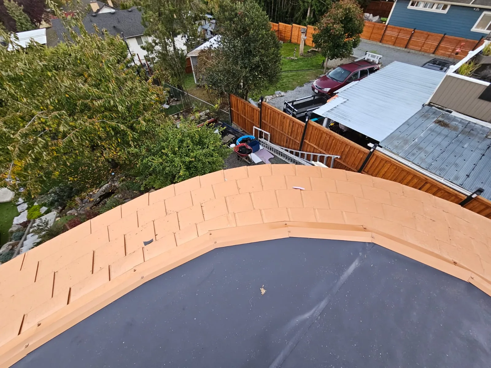 Copper Penny Interlock Slate aluminum roof on a grey home with a metal roof in a suburban neighbourhood, Victoria, British Columbia