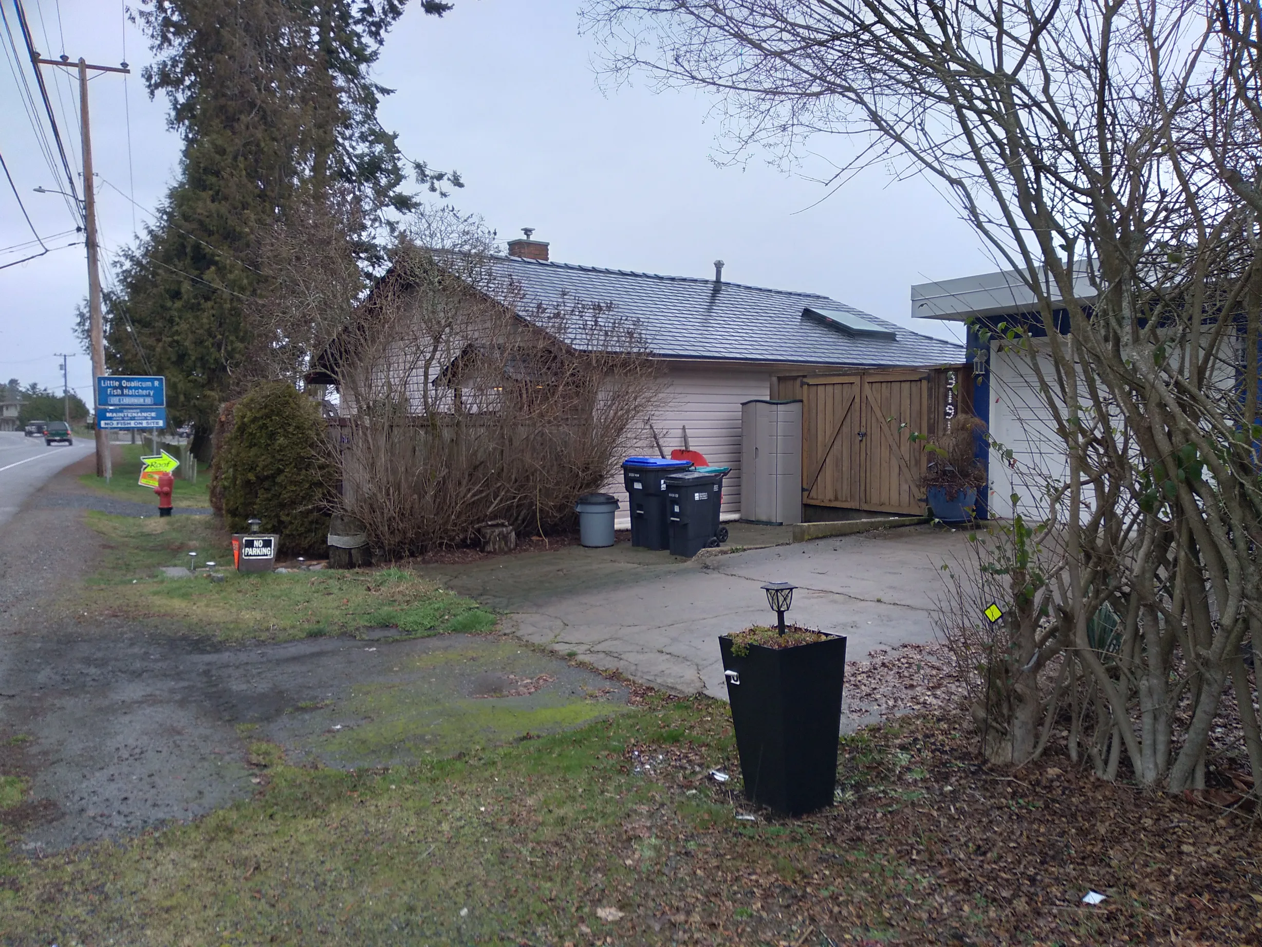Black Interlock Slate aluminum roof on a white single-family home with a metal roof in a rural, Qualicum, British Columbia