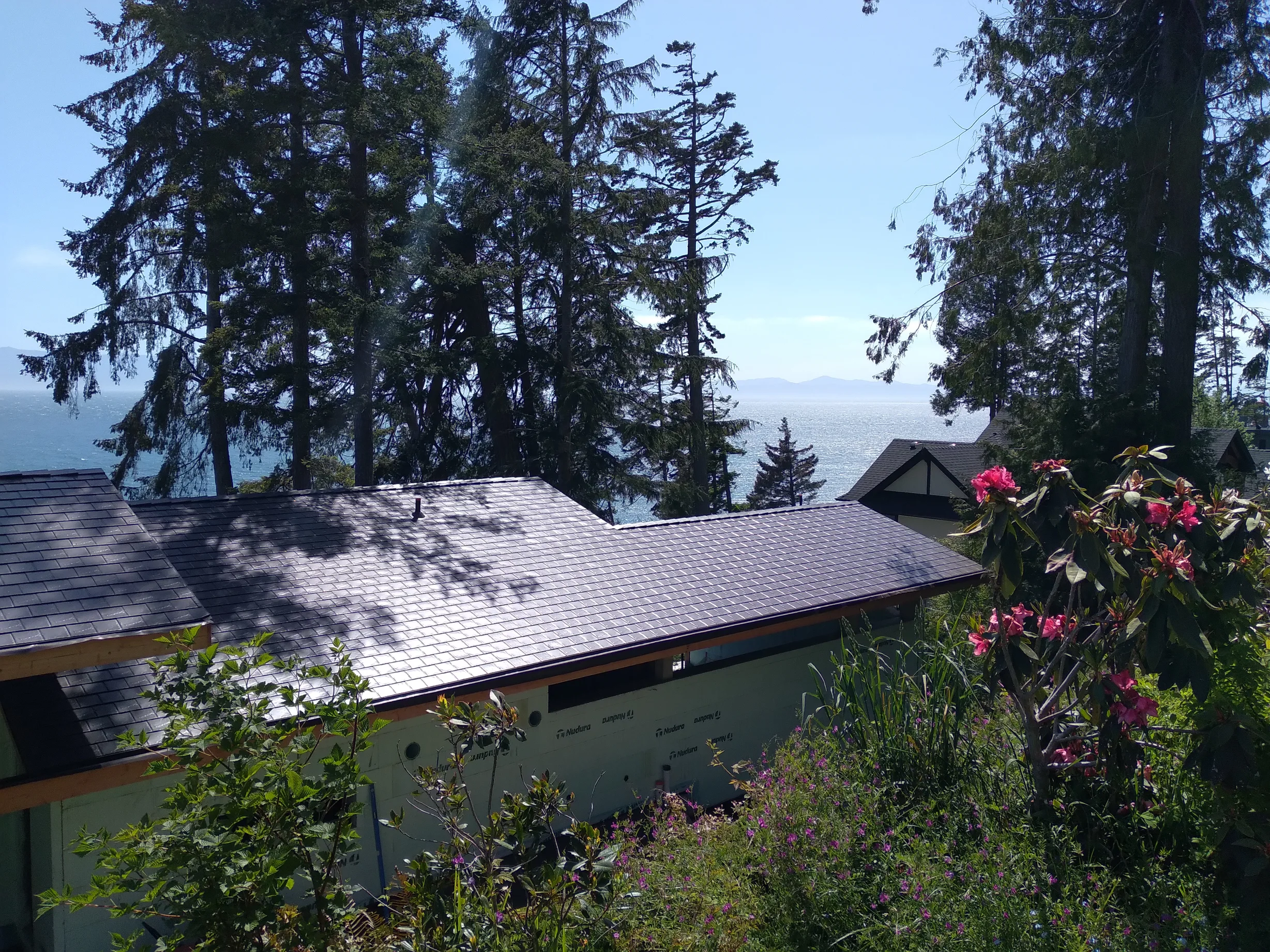 Tudor Brown Interlock Slate aluminum roof on a light green one-storey home with a Tudor brown metal roof, Shirley, British Columbia