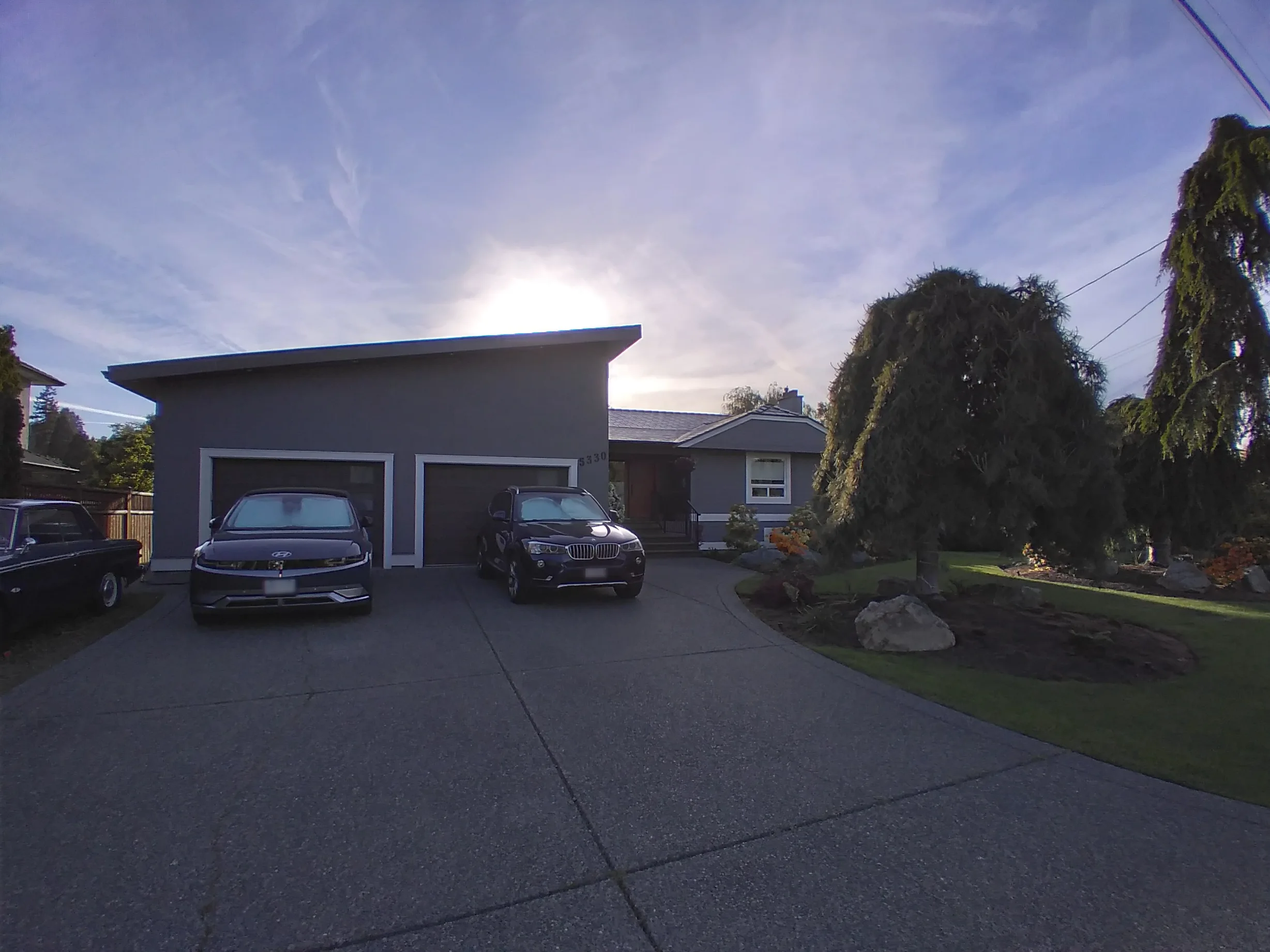 Deep Charcoal Interlock Slate aluminum roof on a grey house with a metal roof and a tree in the front yard, Victoria, British Columbia