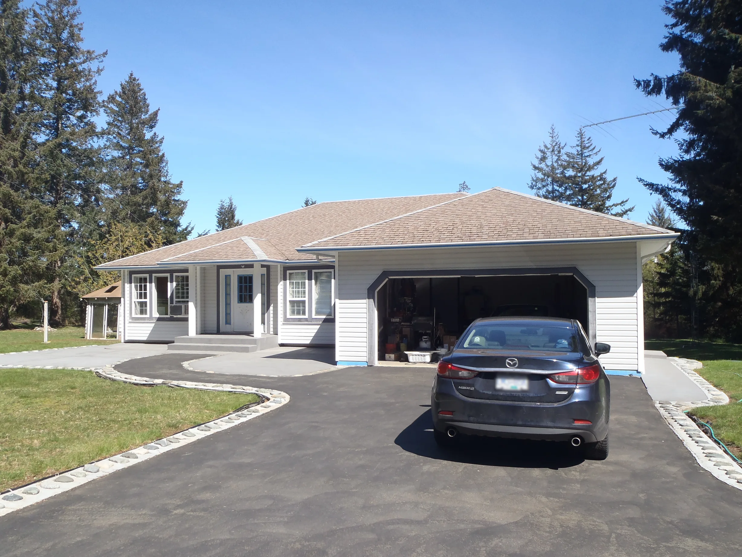 Before: a worn out asphalt shingle roof on the home, Courtenay, British Columbia, ahead of a Deep Charcoal Interlock Slate aluminum roof