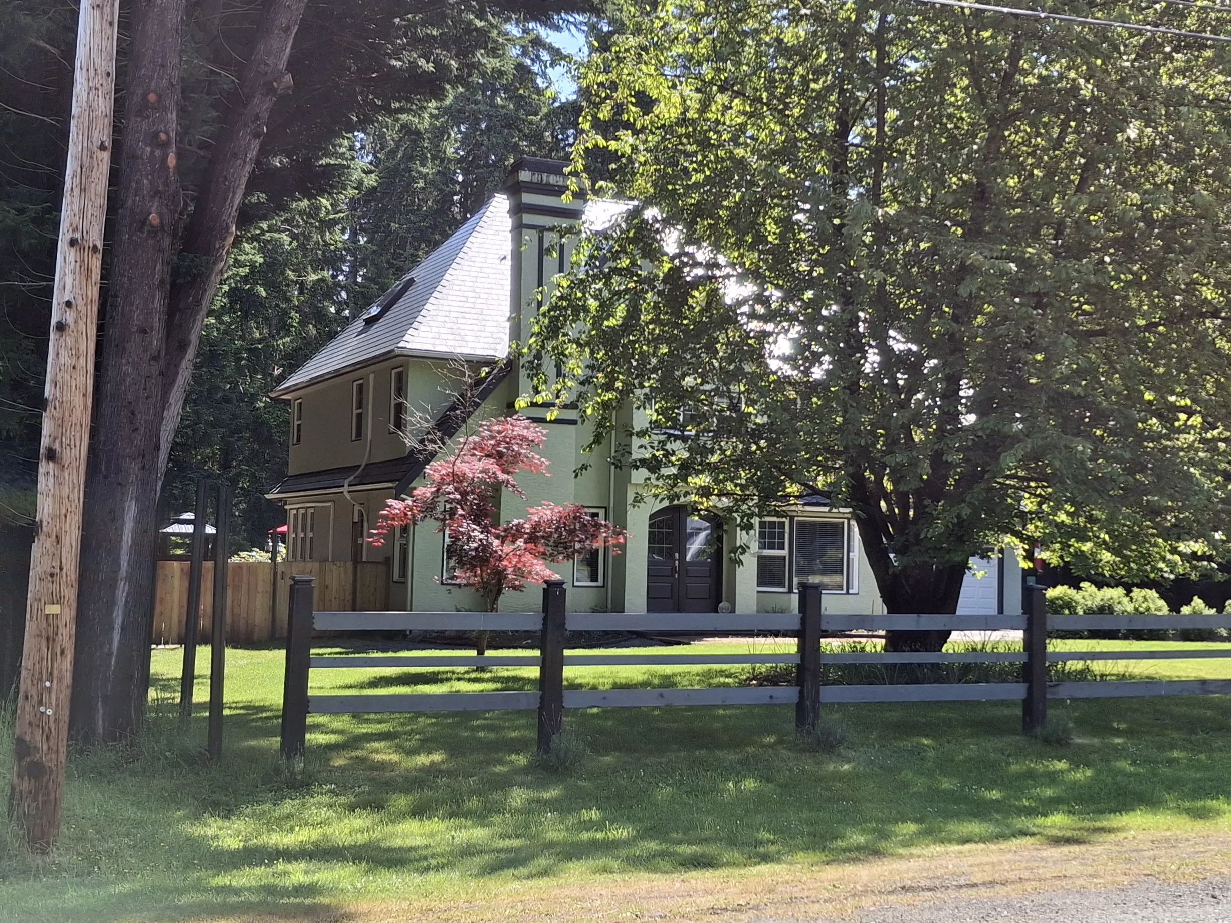 Deep Charcoal Interlock Slate aluminum roof on a two-storey home with dormers in a lush green yard, Bowser, British Columbia